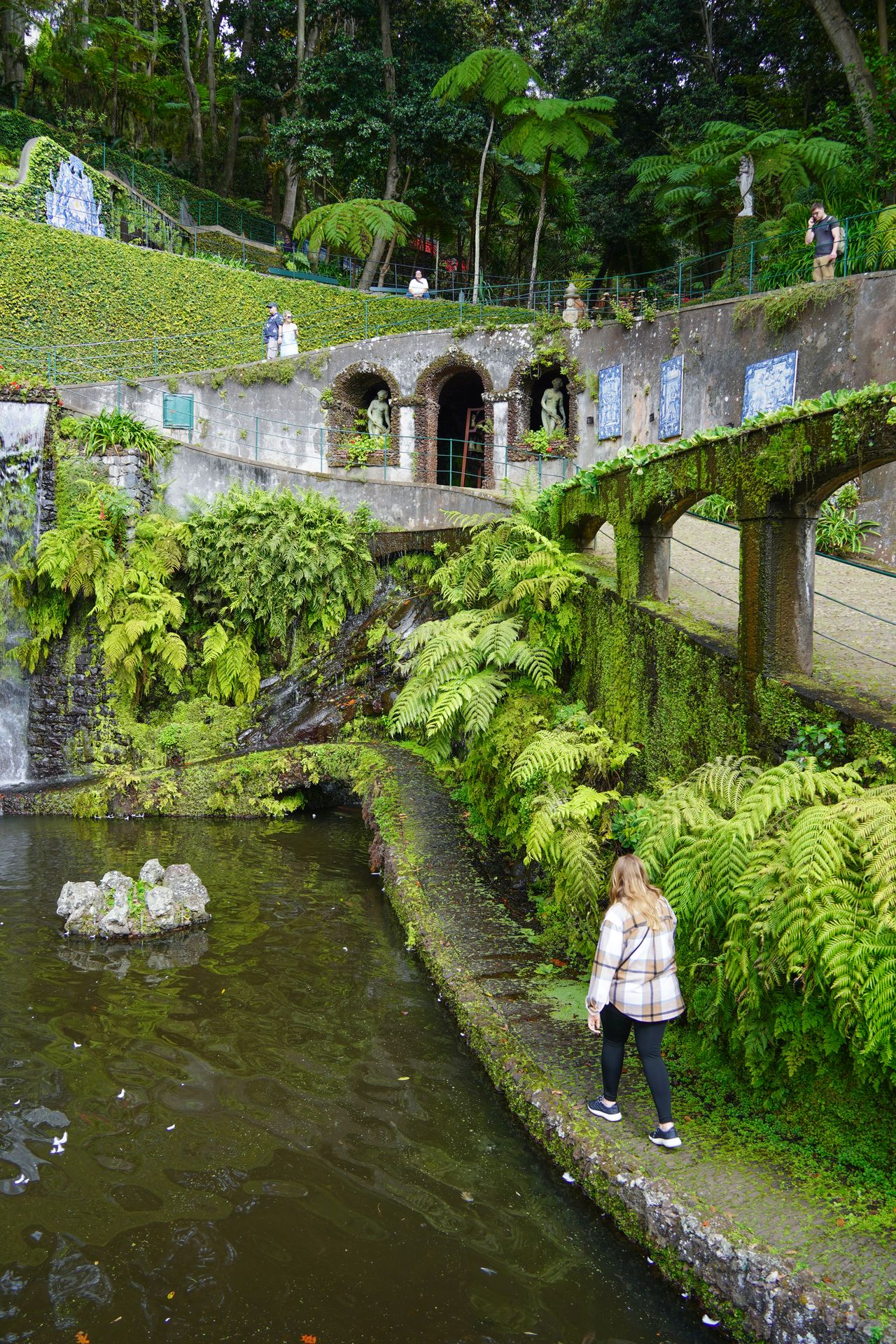 Lydia walking along a path next to water in the Monte Palace Gardens