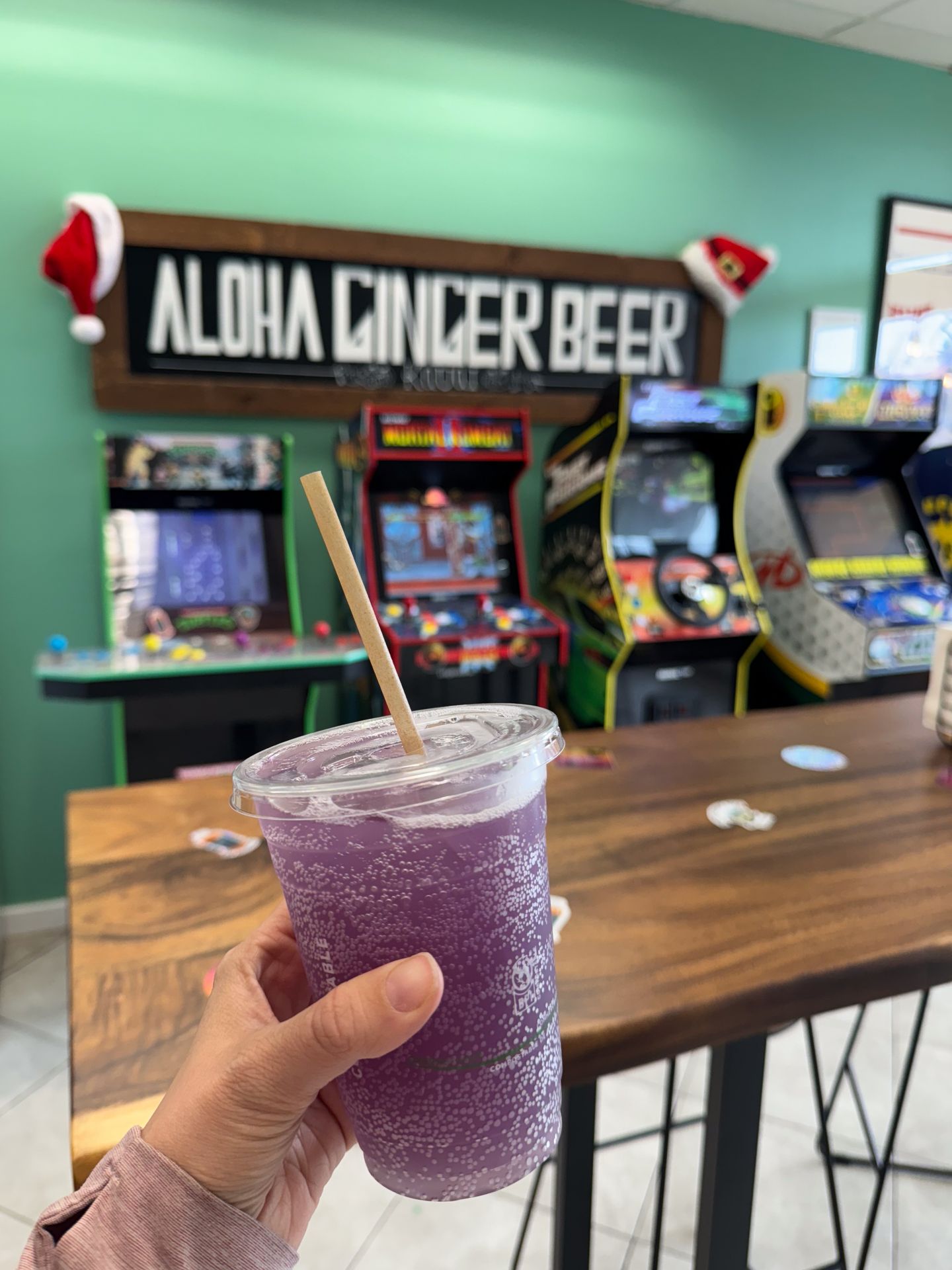 Holding up a purple ginger beer drink inside of Aloha Ginger Beer