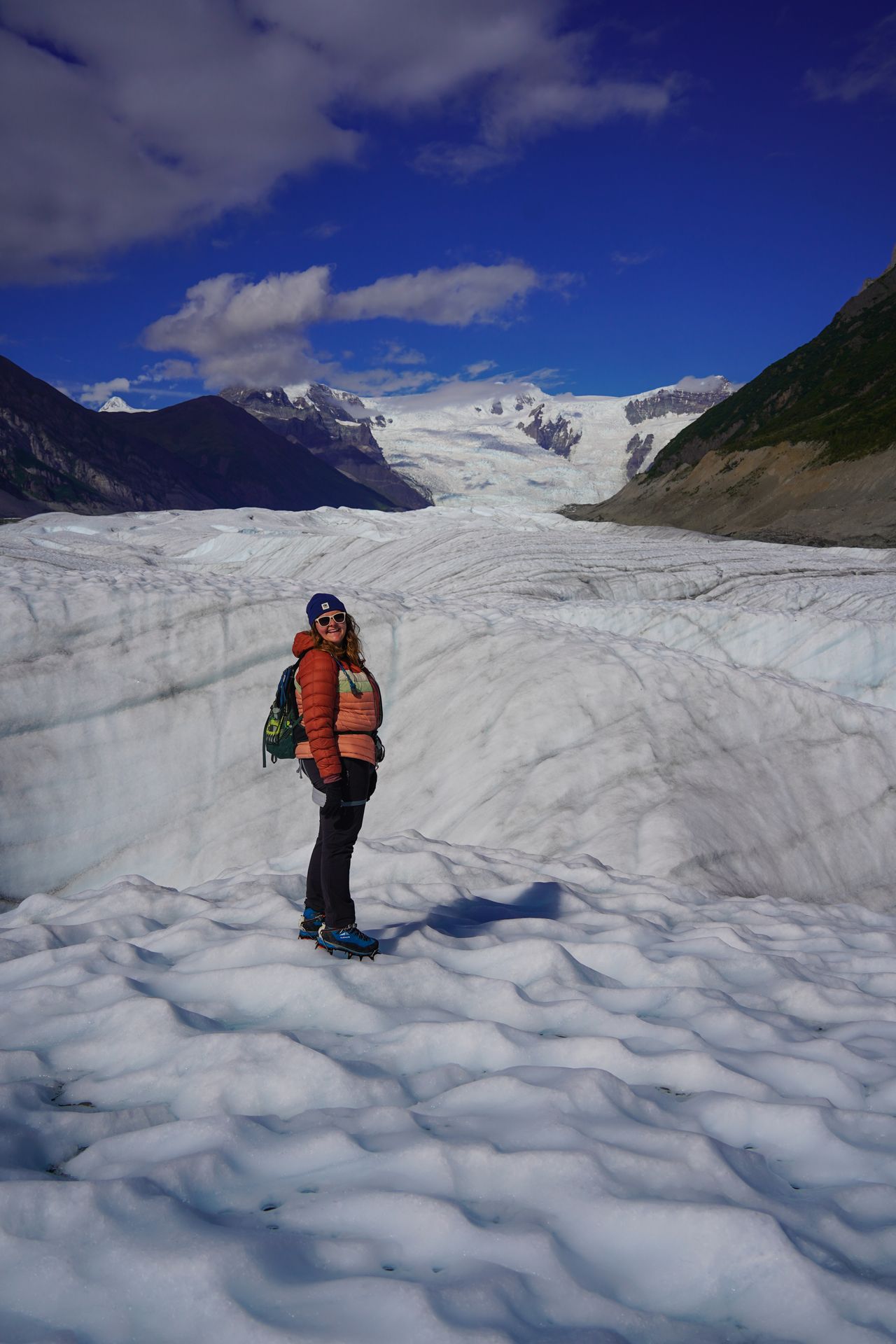 Lydia standing on the Root Glacier with mountains in the distance