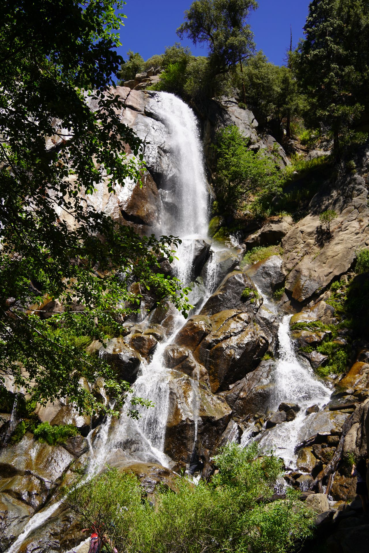 A waterfall cascading down over a rock wall and boulders