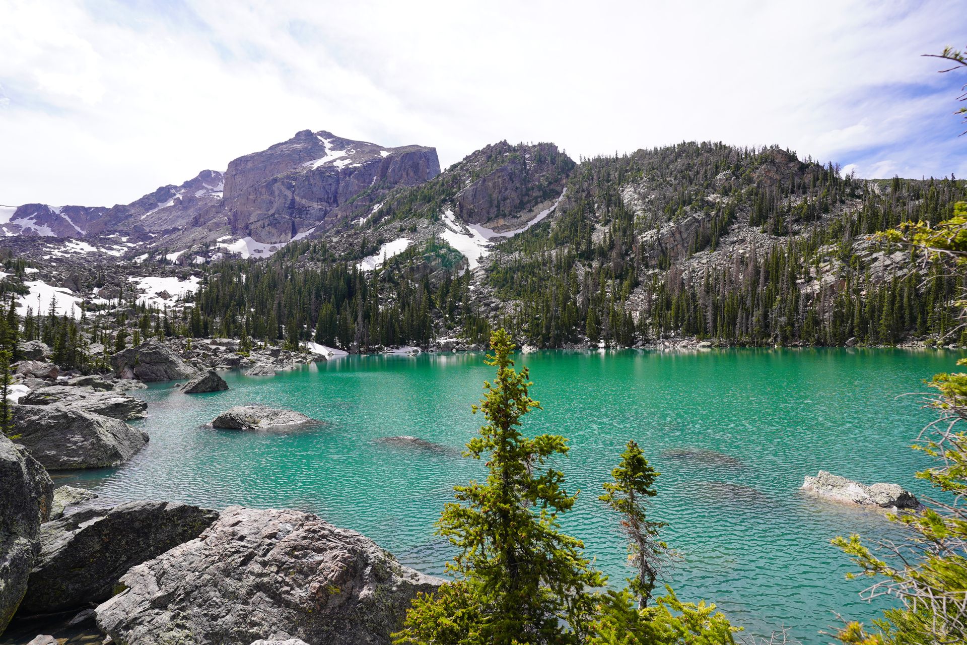 A view looking down at Lake Haiyaha, which is a bright, green color.