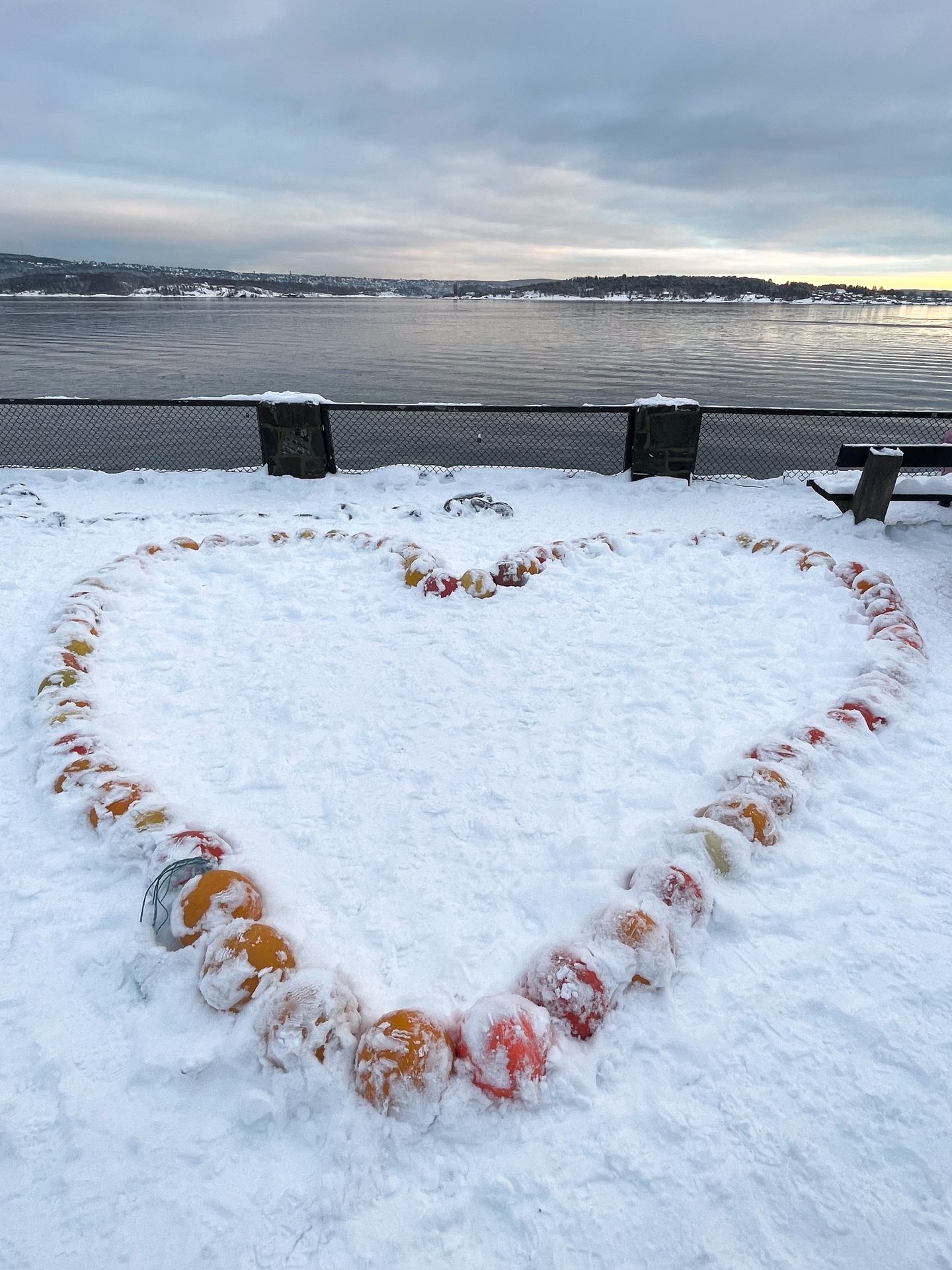 A sculpture of a heart partially covered in snow