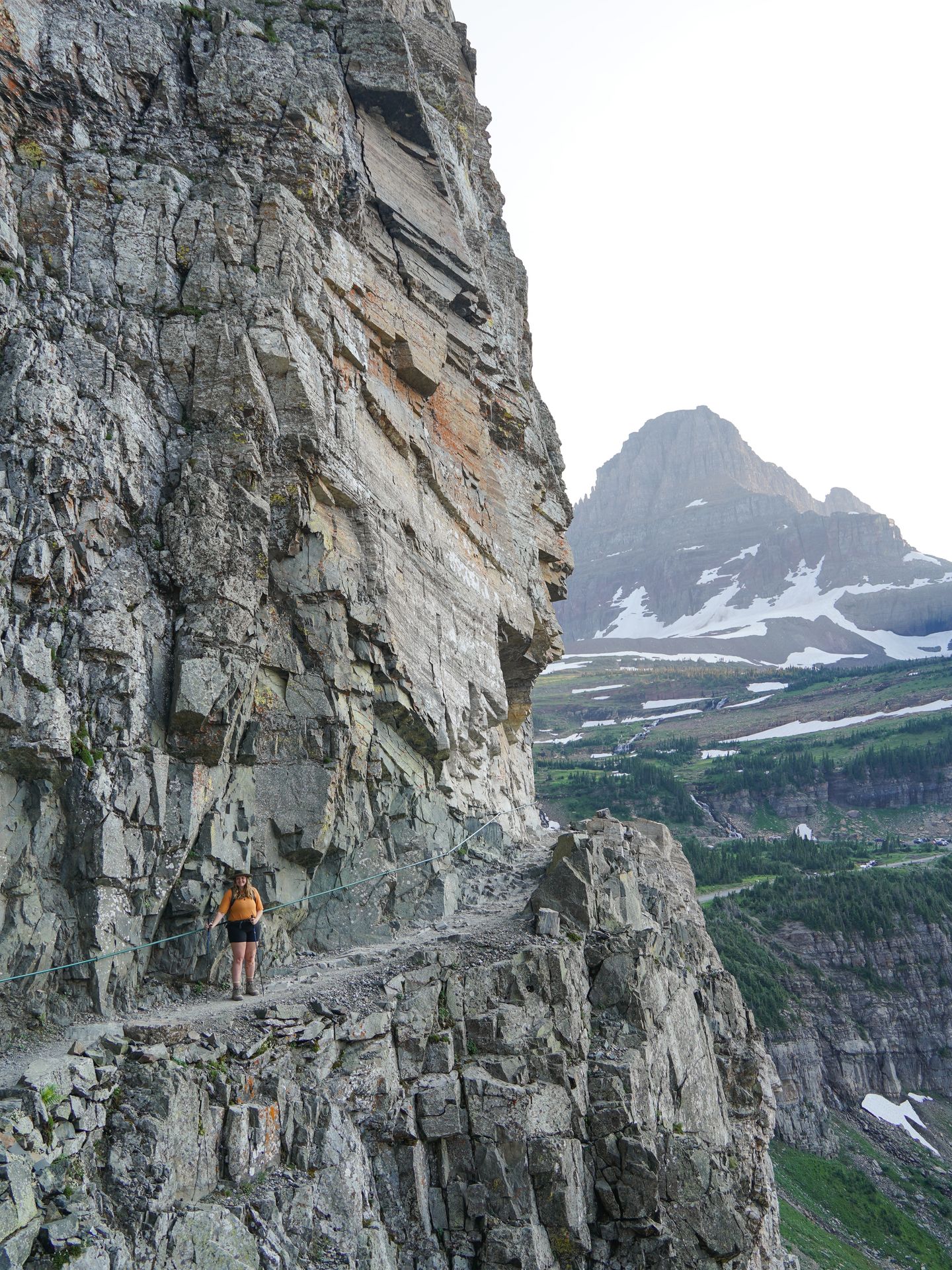 Lydia standing on a narrow ledge on the Highline Trail in Glacier National Park