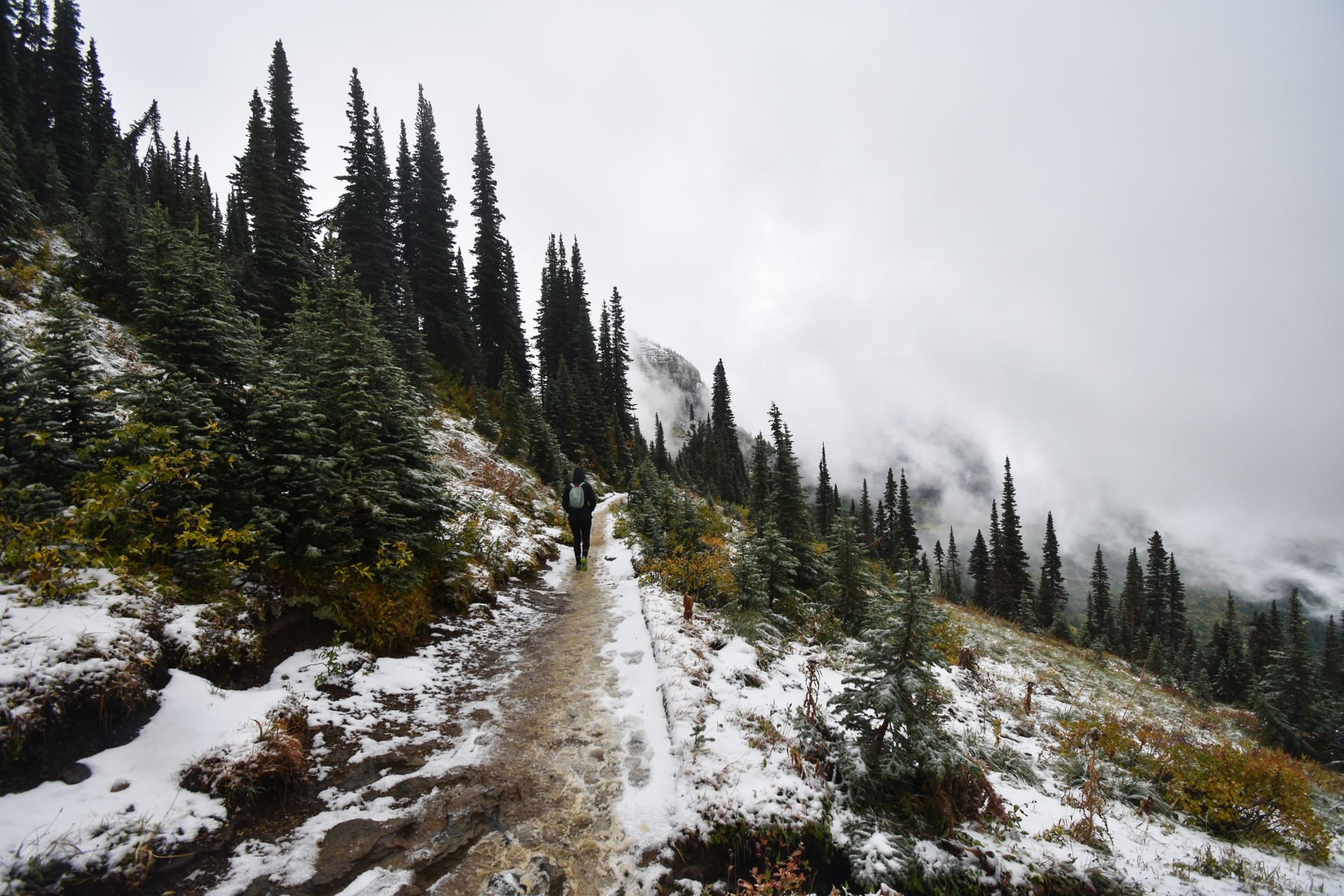 Some hiking on a narrow trail with a little bit of snow on the Highline Trail.