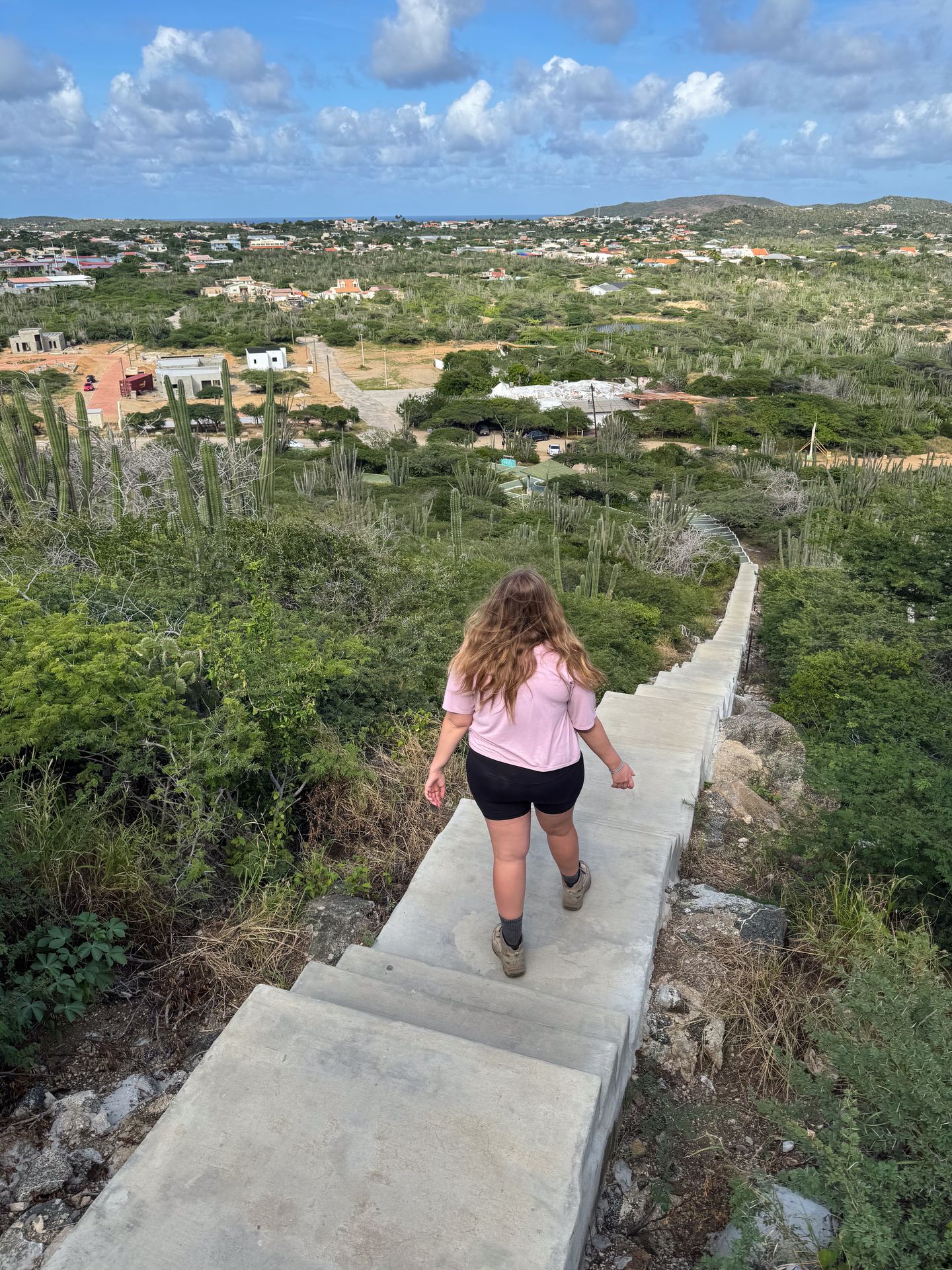 Lydia hiking down the steps to the top of Mount Hooiberg