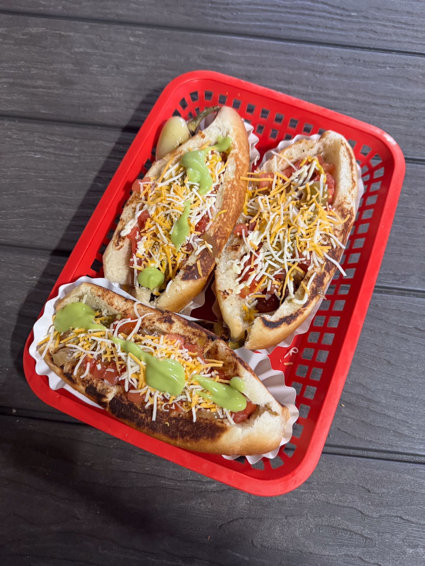 A red basket with 3 large sonoran hot dogs