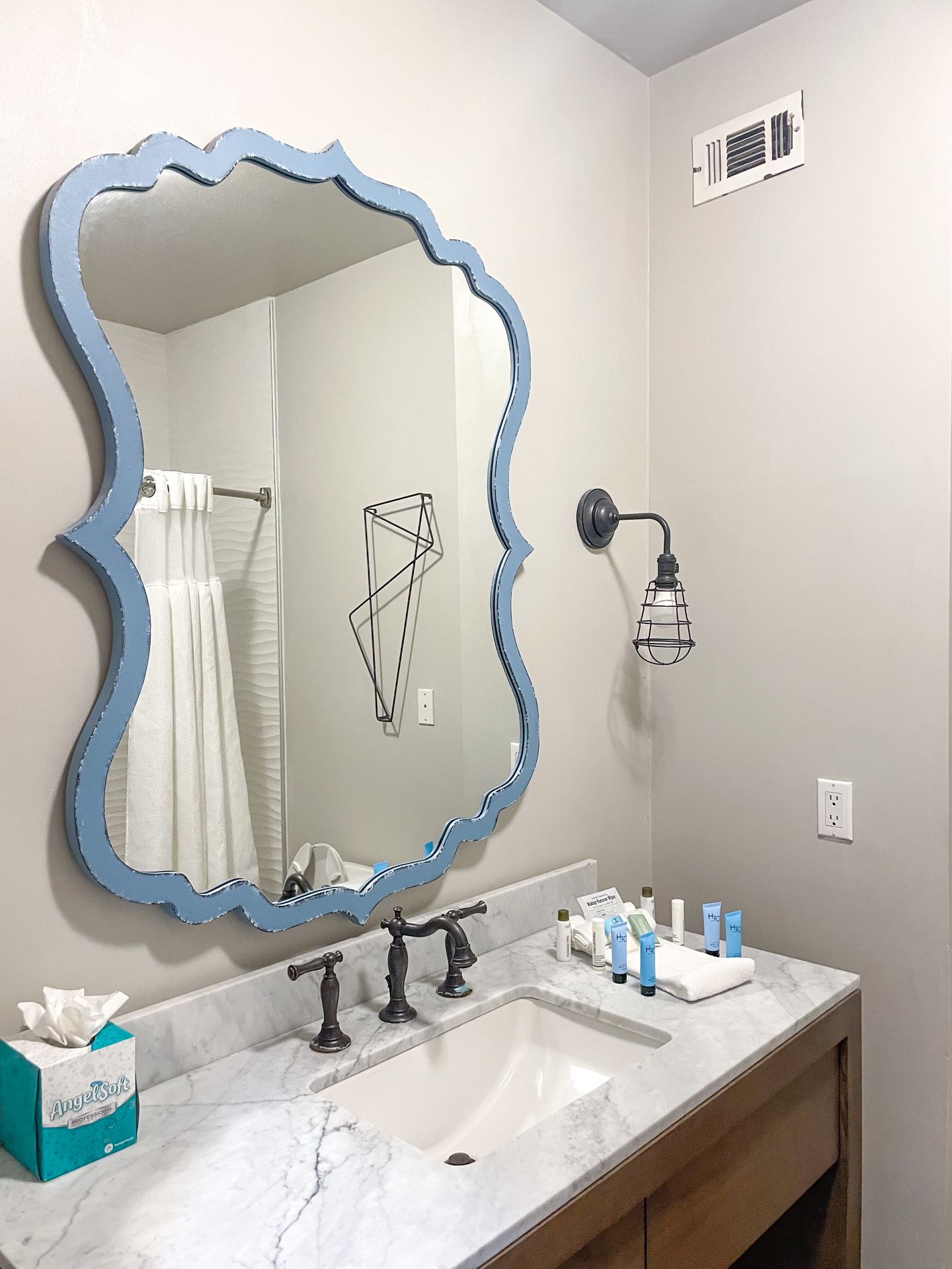 A mirror with a blue frame in the bathroom of a room at Hotel Ylem.