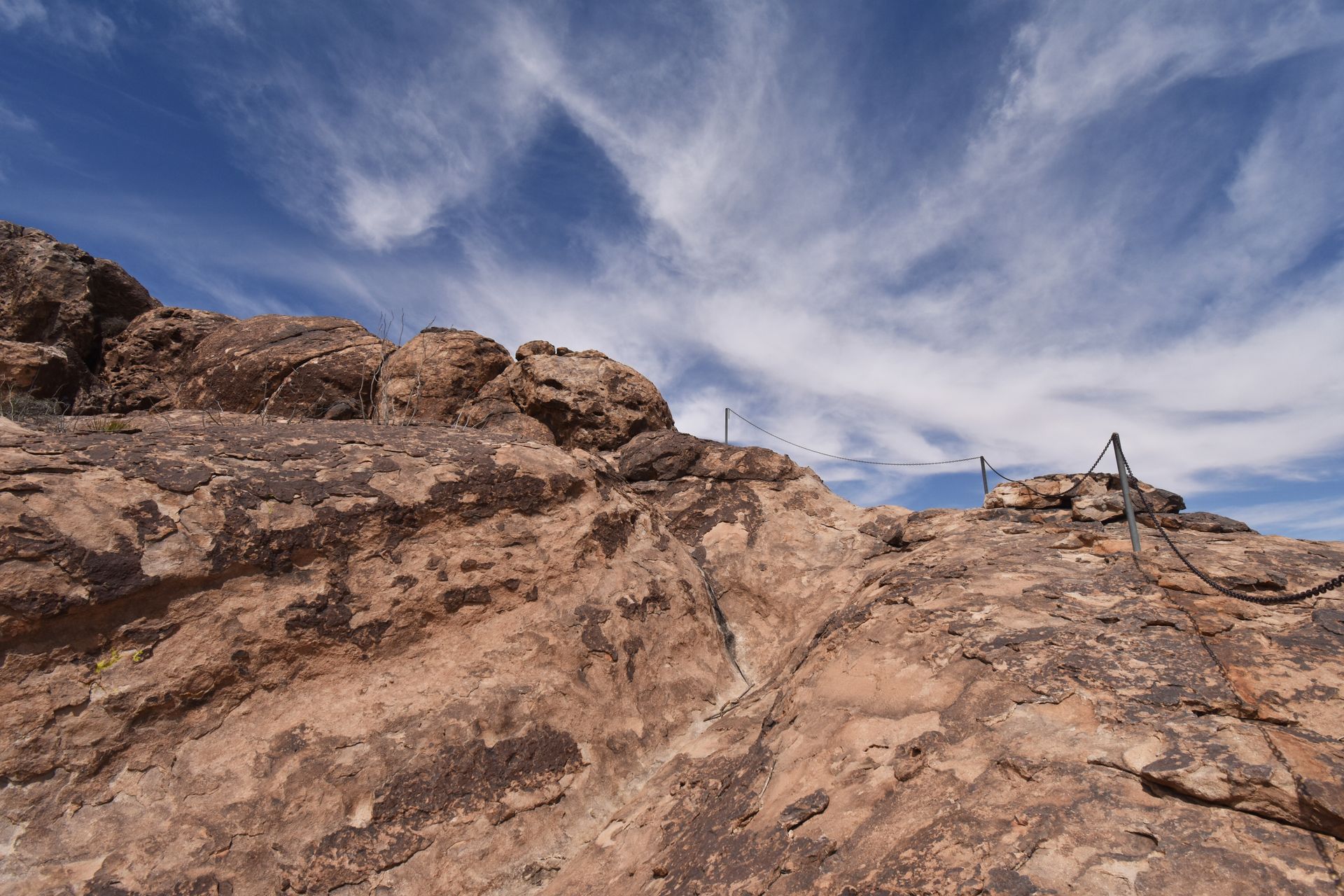 A pole with chains leading to the top of the rock at Hueco Tanks.