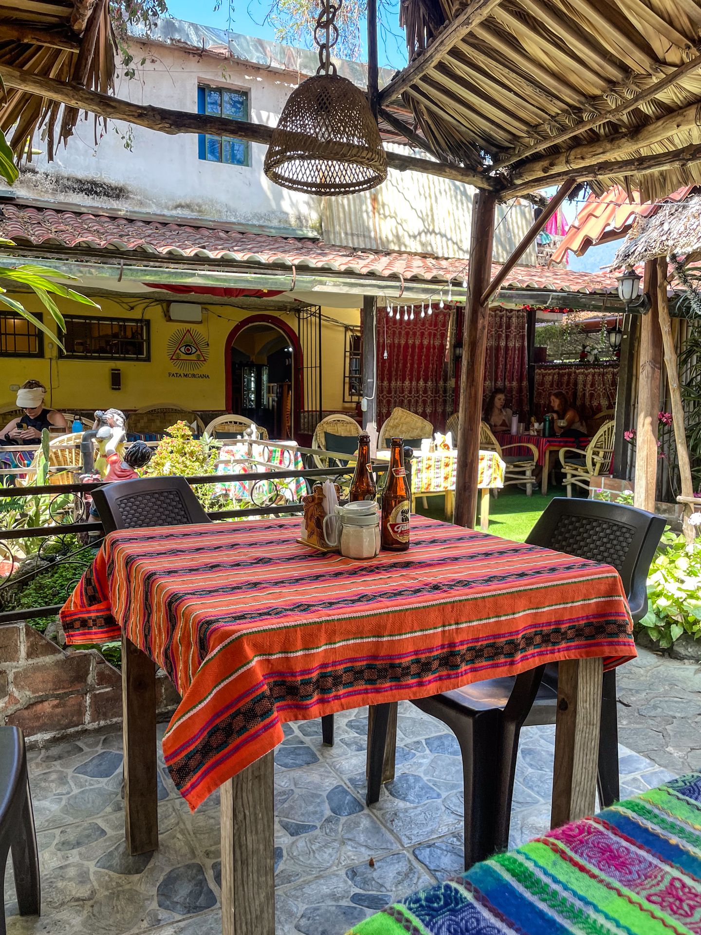 The outdoor patio of Cafe Bakery and Restaurant Idea Connection, which has colorful tablecloths and covered areas