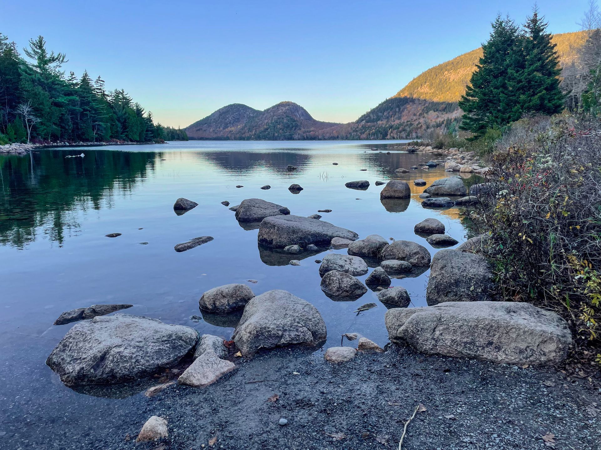 Looking across Jordan Pond at two, round mountain peaks.