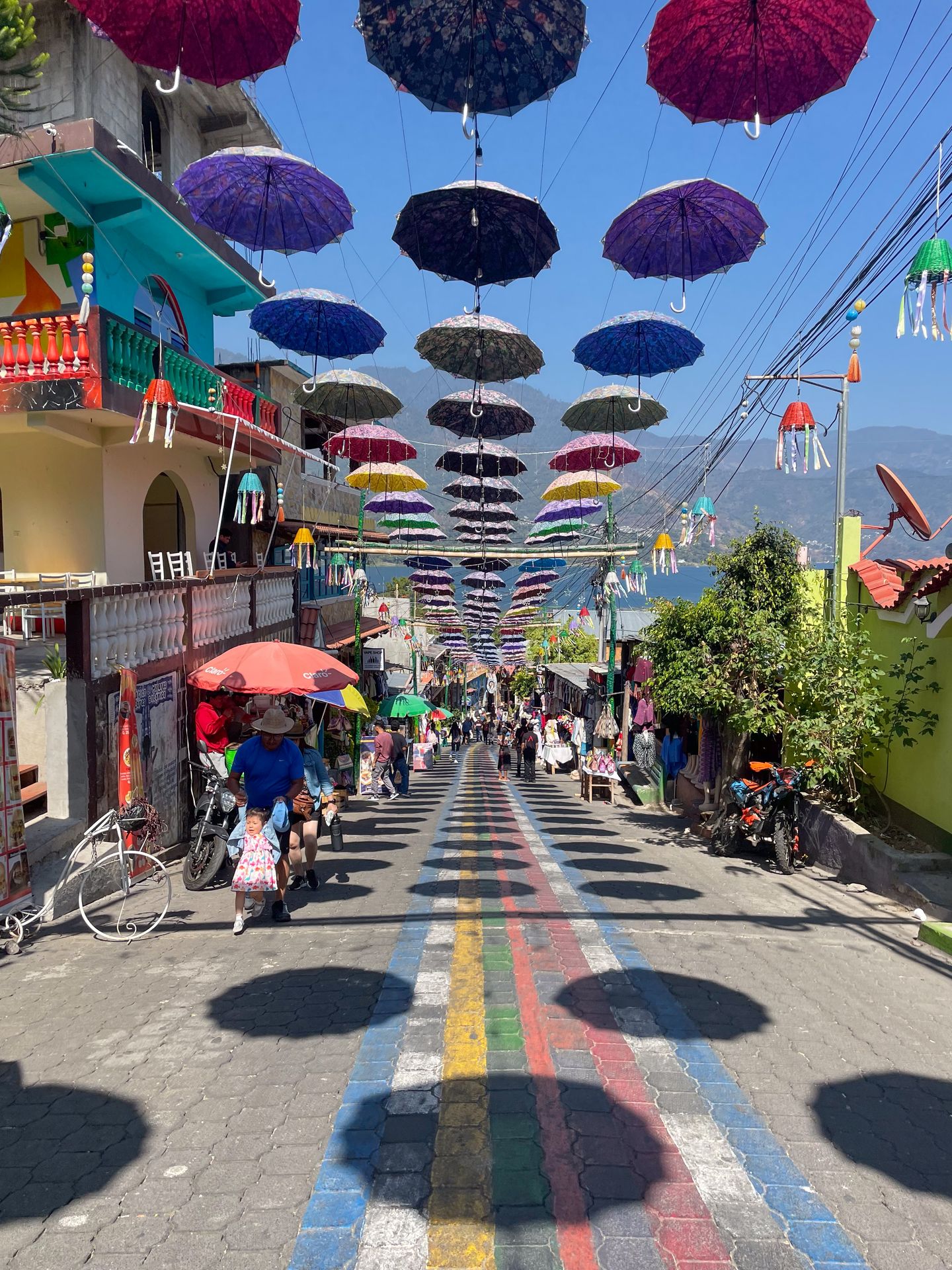 A street with umbrellas hung above it in San Juan La Laguna