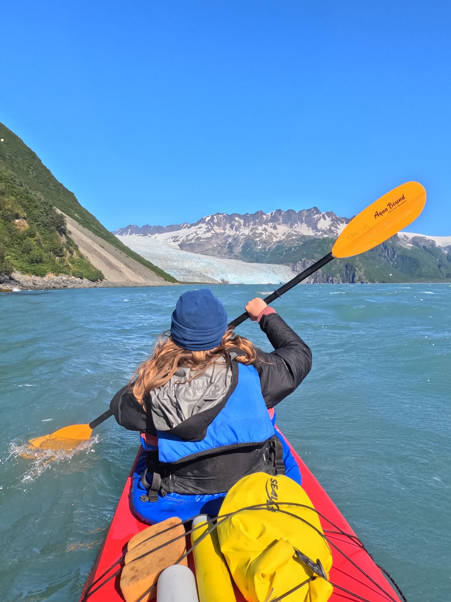 Lydia kayaking at the front of a tandem kayak near Aialik Glacier in Kenai Fjords National Park