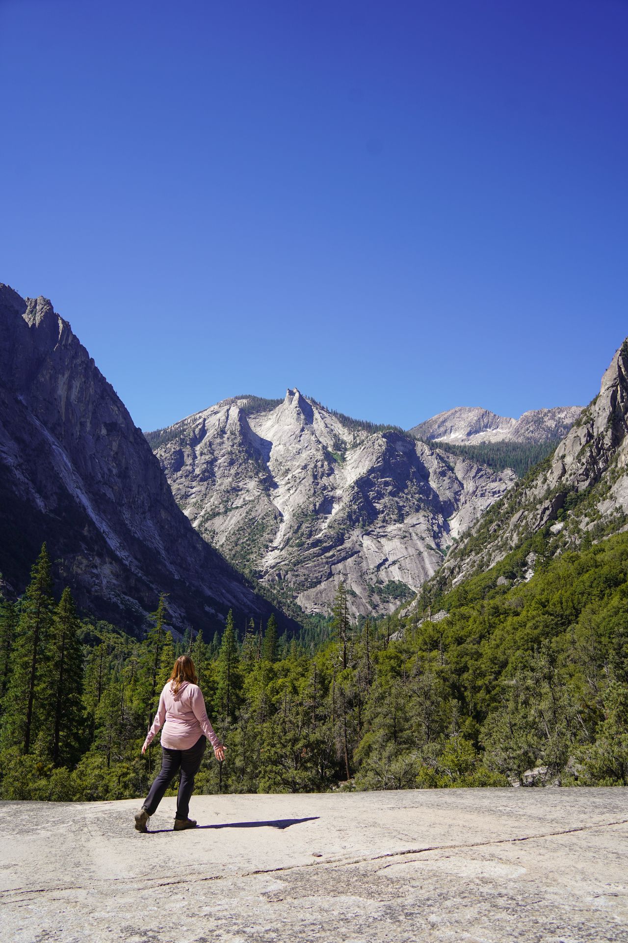 Lydia looking out at tall canyon walls on a trail in Kings Canyon