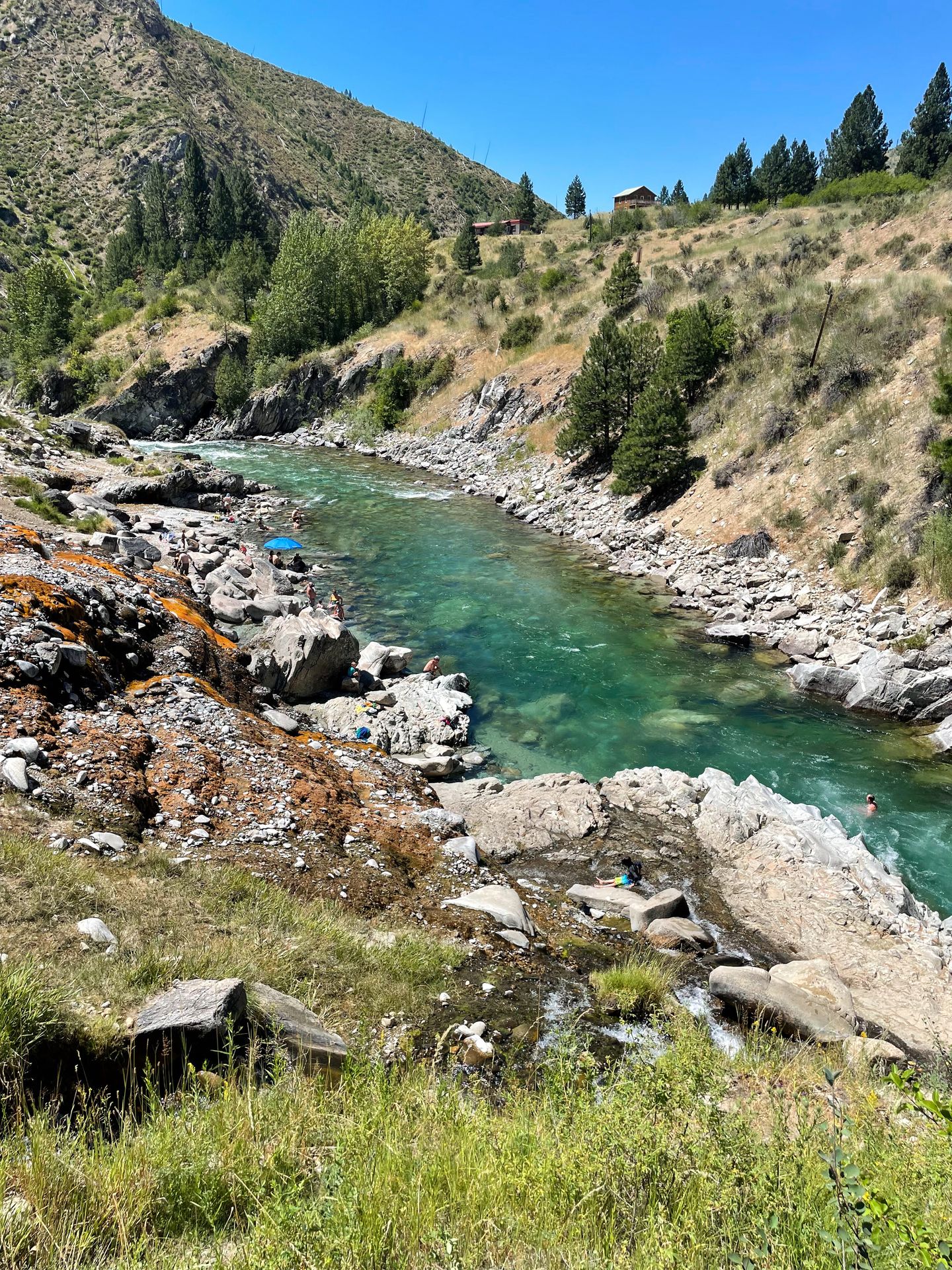 A view of the Kirkhan Hot Springs next to the Payette River, which is a beautiful aqua blue color