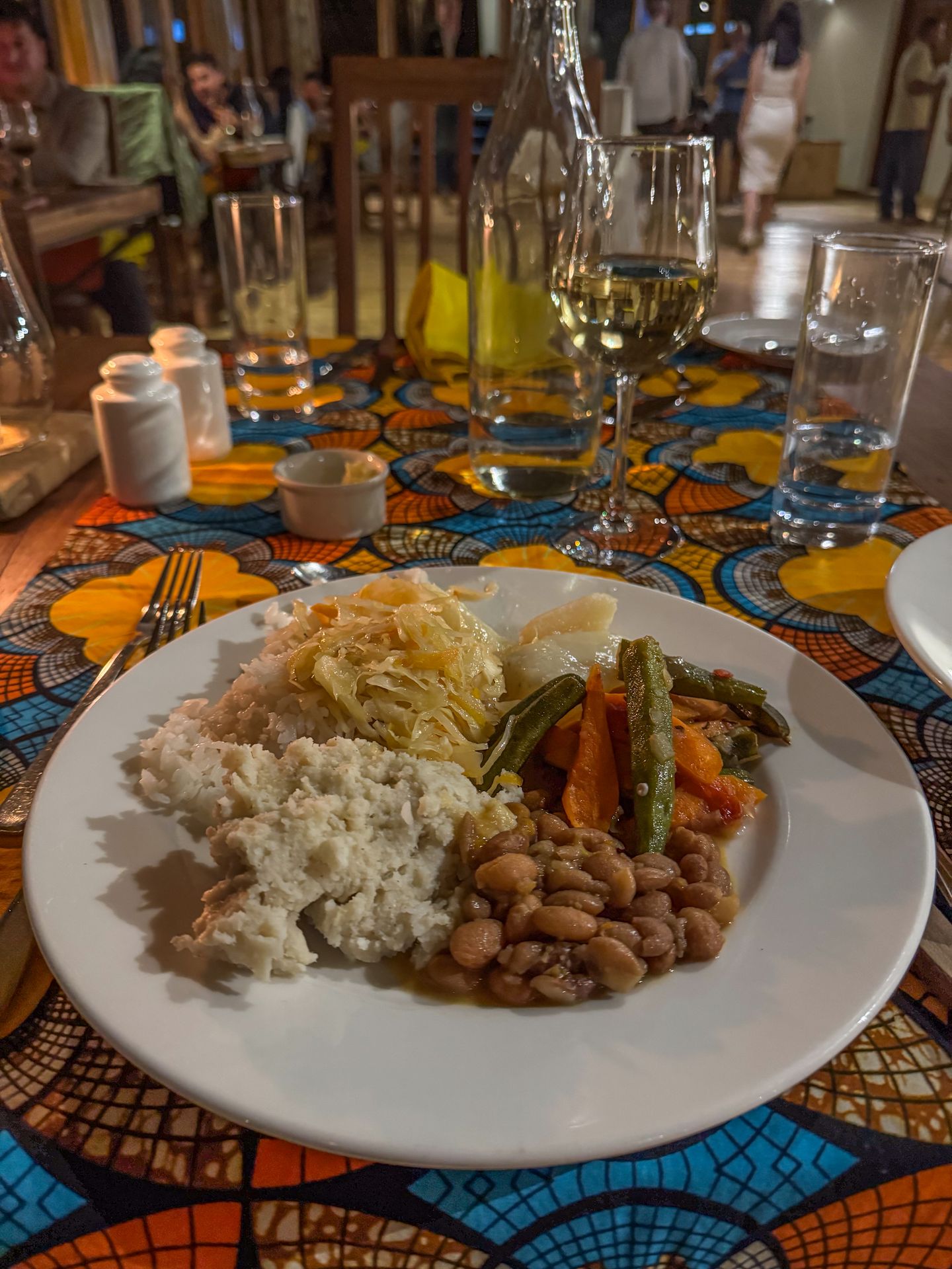 A plate from a buffet, which includes beans, vegtables and potatoes