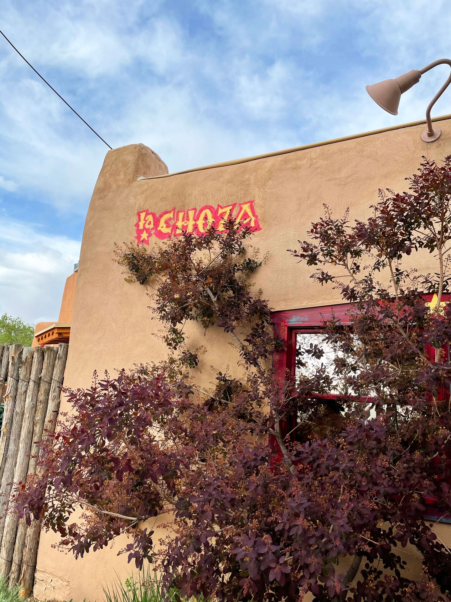 The exterior of La Choza. There is Pueblo style architecture and words La Choza written in the corner on the corner of the building.
