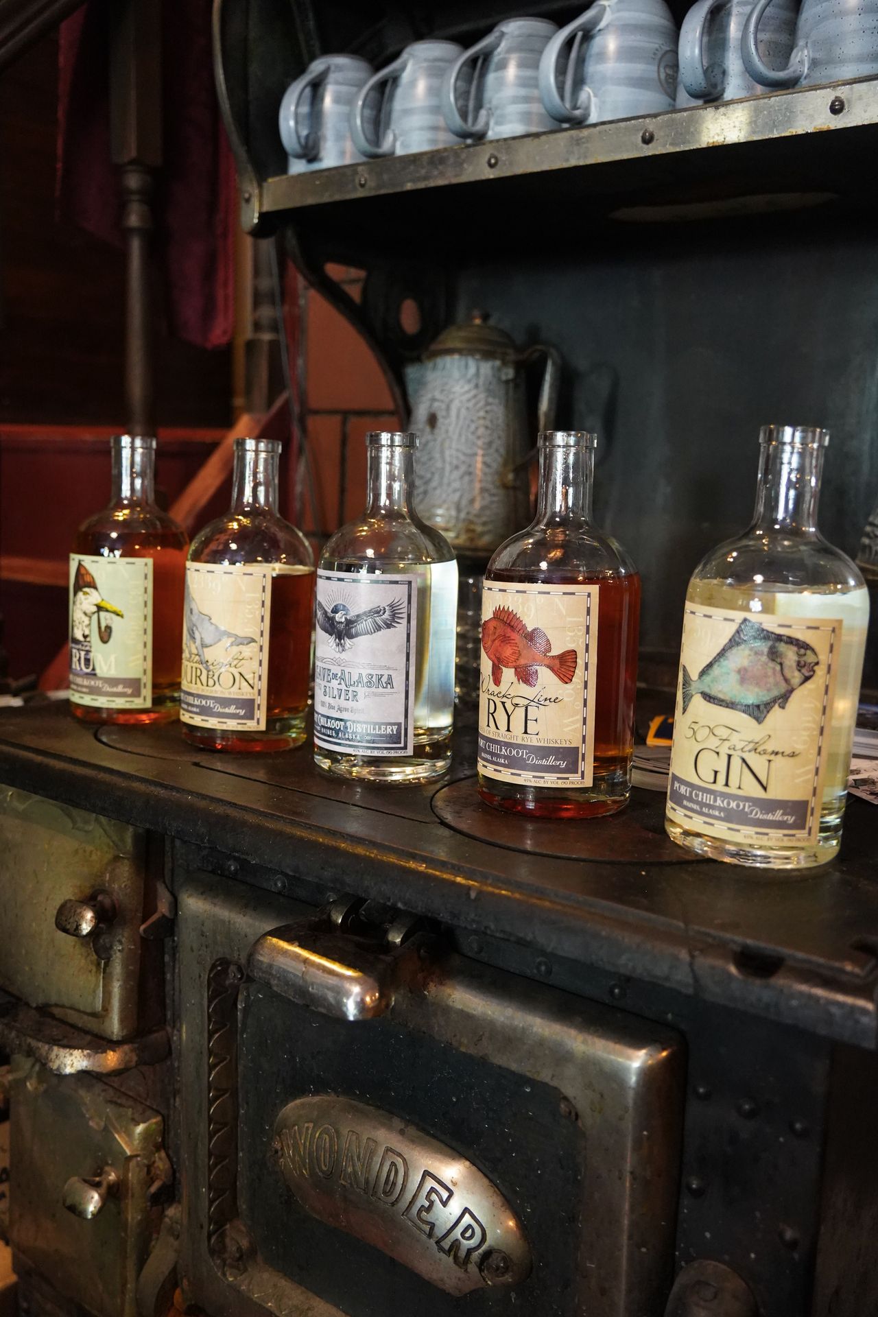 A row of 5 different liquor bottles during the pairing dinner at Salmon & Bear