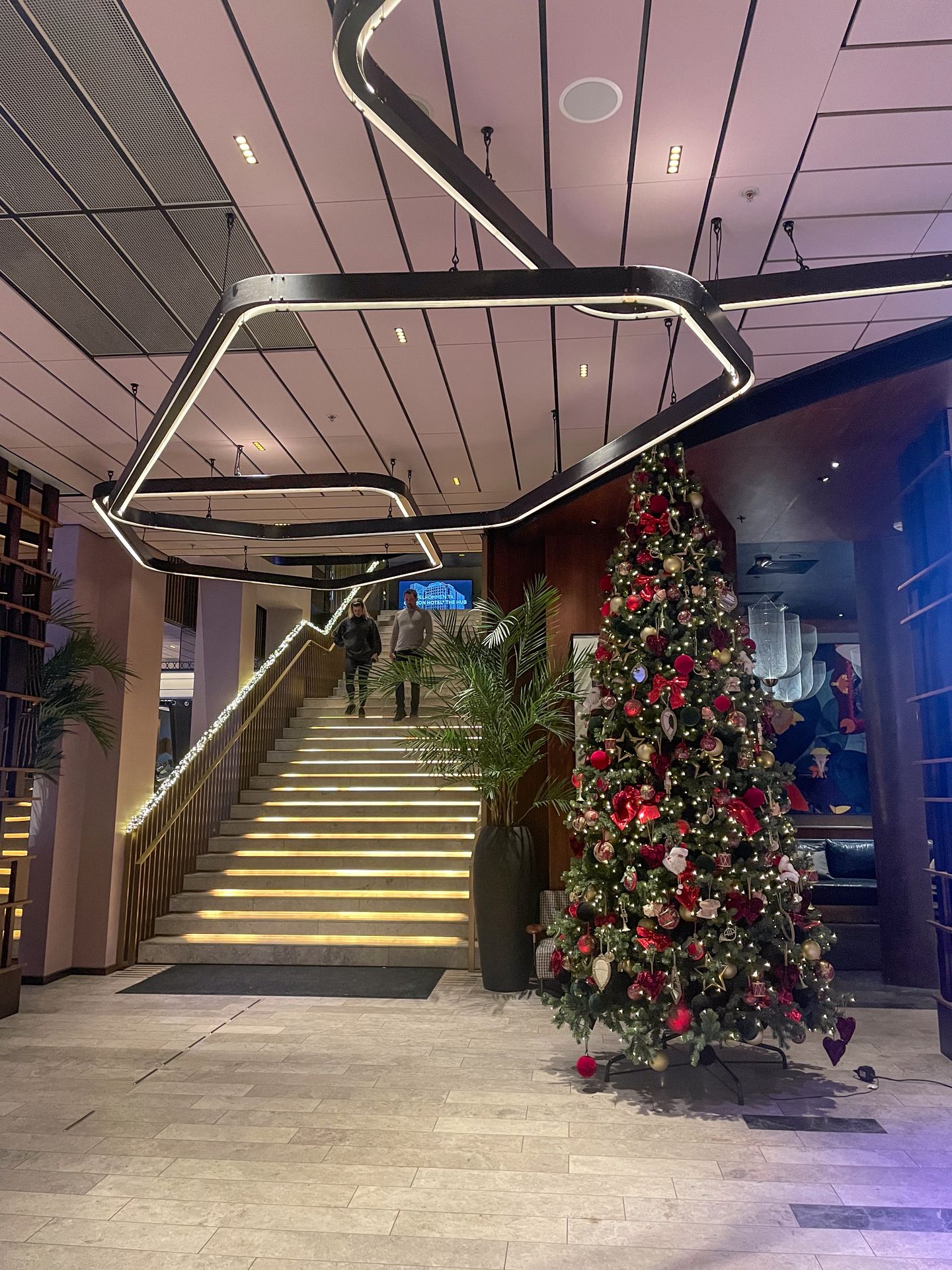 The lobby of Clarion Hotel The Hub, with a large Christmas tree and a lit-up ceiling.