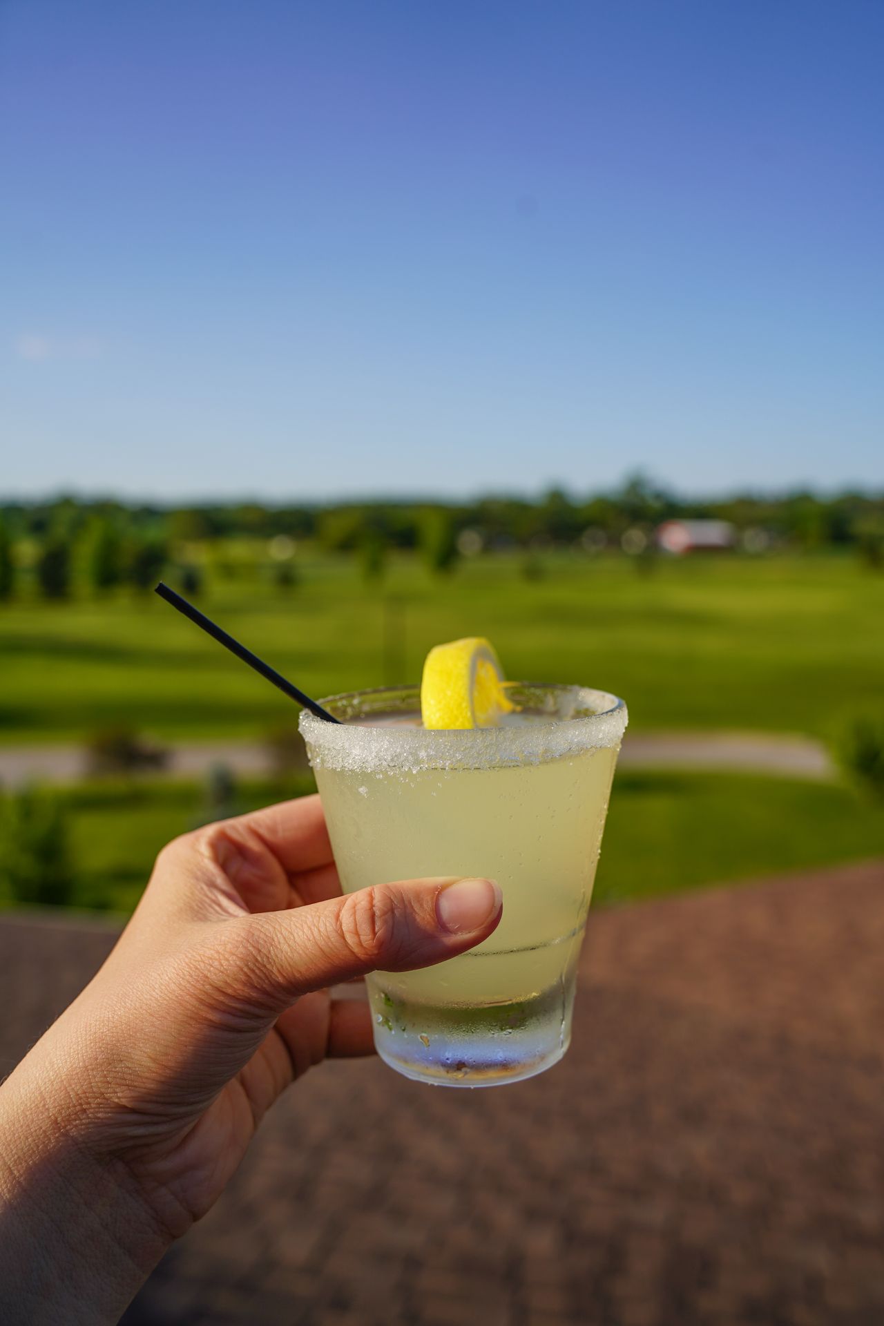 Holding up a cocktail from the rooftop lounge at Norfolk Lodge and Suites