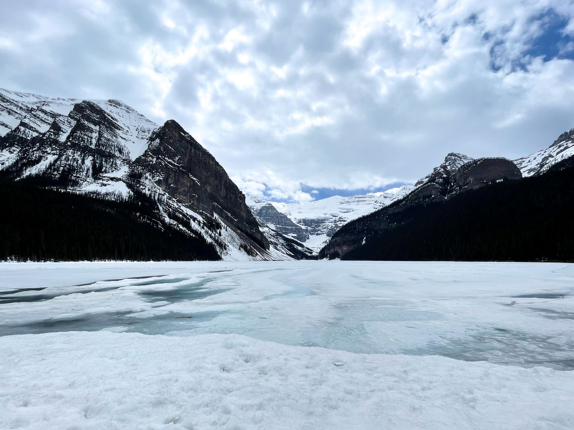 A frozen lake with mountains on the opposite side.