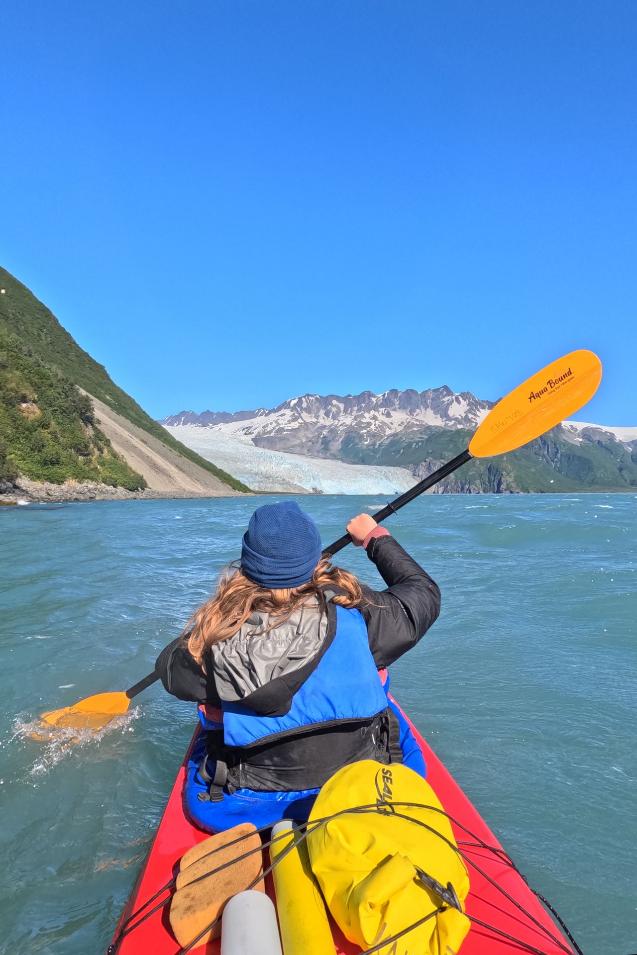 Lydia kayaking at the front of a tandem kayak near Aialik Glacier in Kenai Fjords National Park