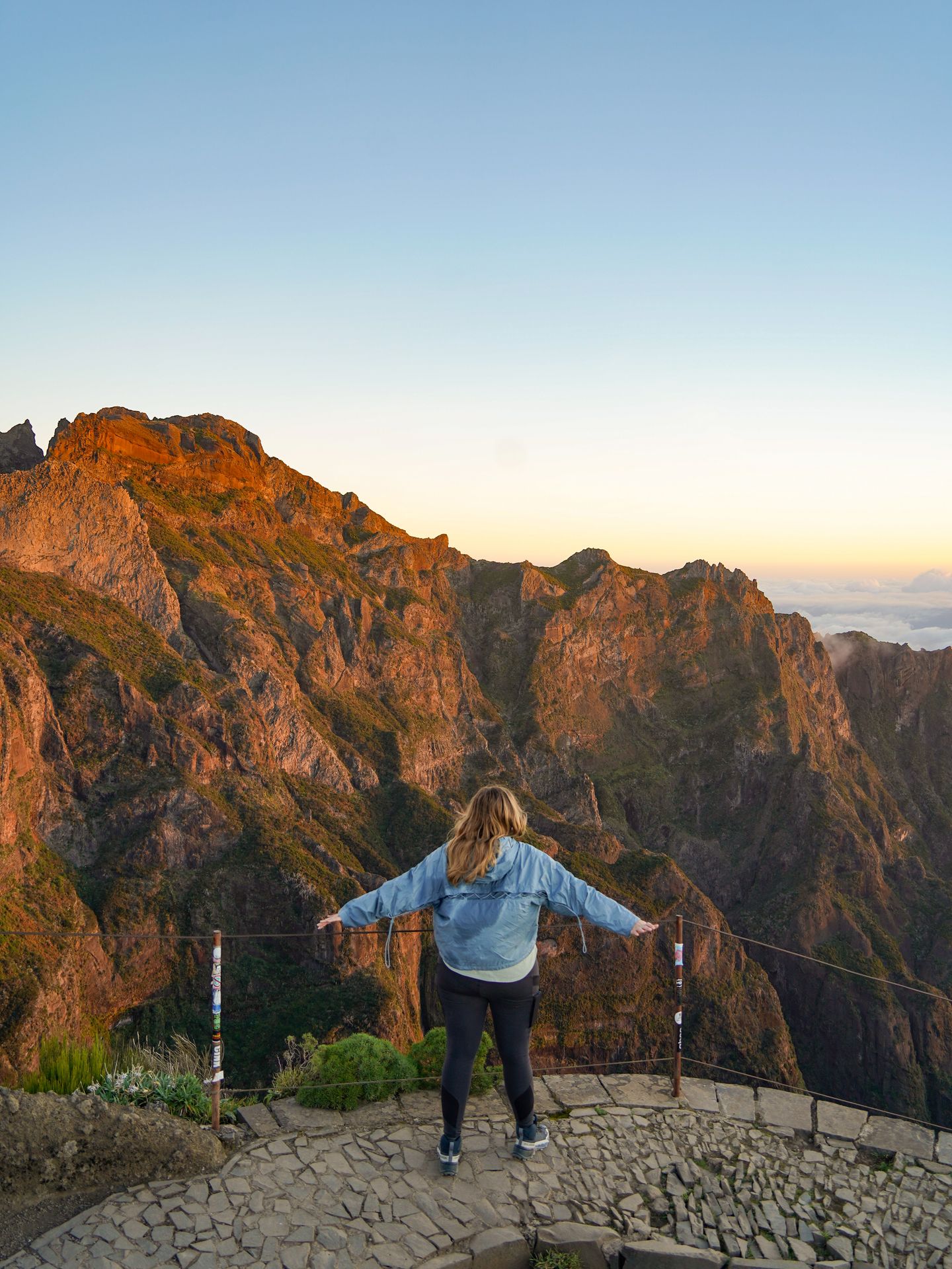 Lydia standing and looking out mountains around sunrise on the PR1 trail.