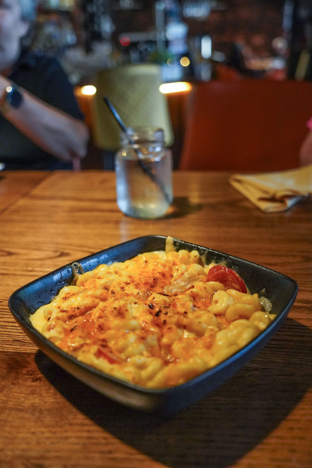 A square bowl full of creamy mac and cheese