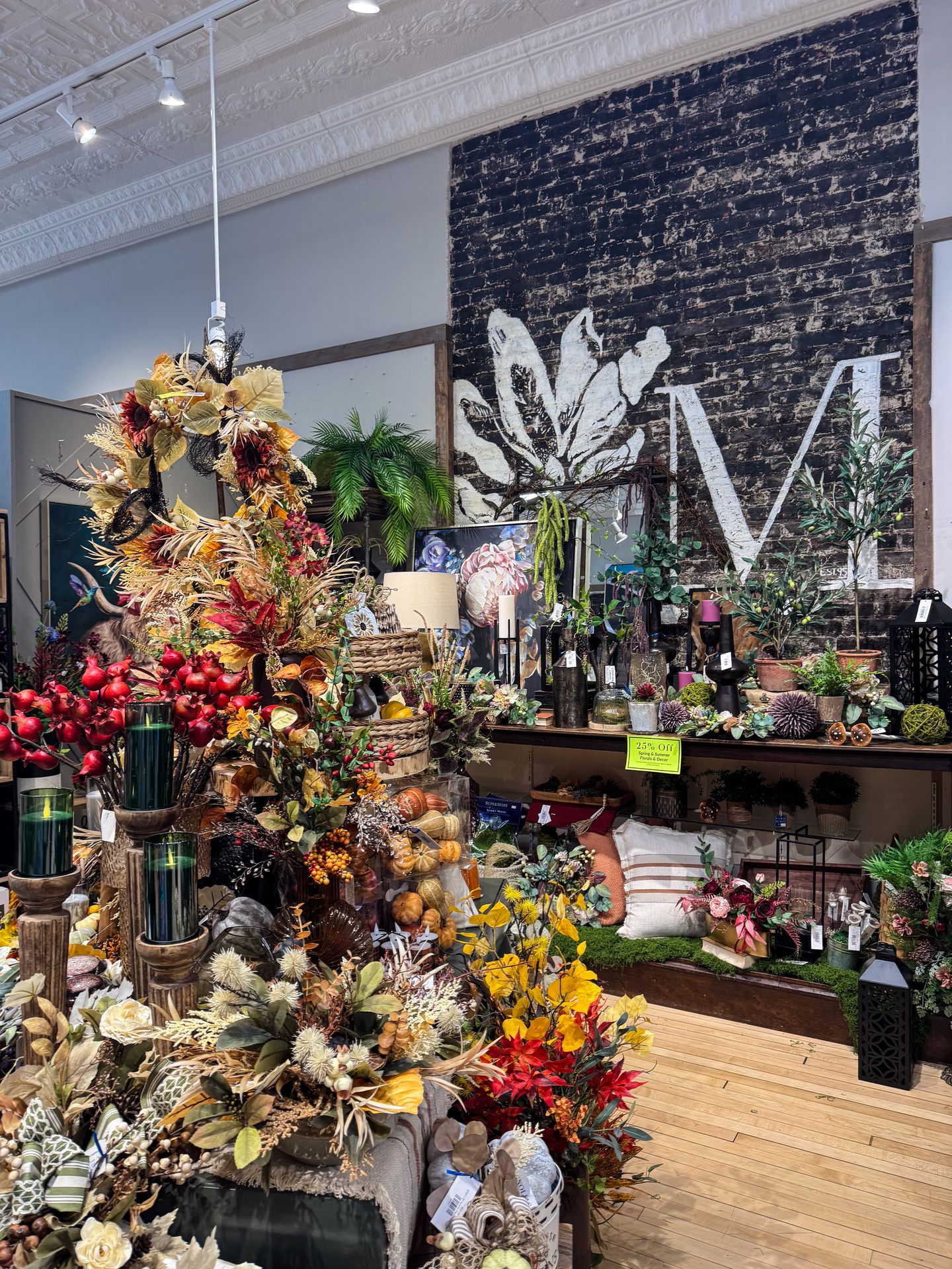 A display with colorful faux flowers and other home decor inside of Magnolias