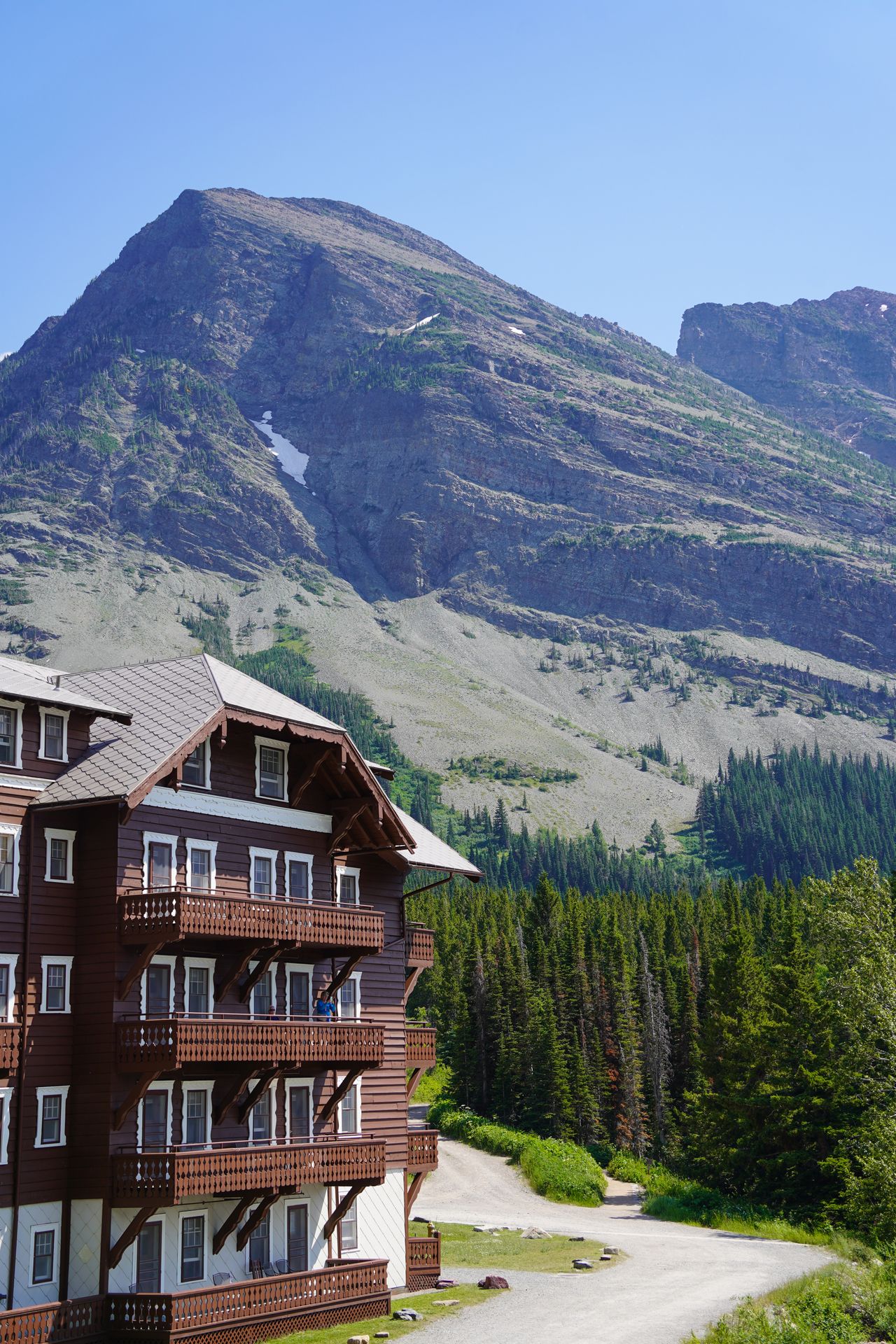 The Many Glacier Lodge with mountains in the background. The lodge resembles Swiss architecture