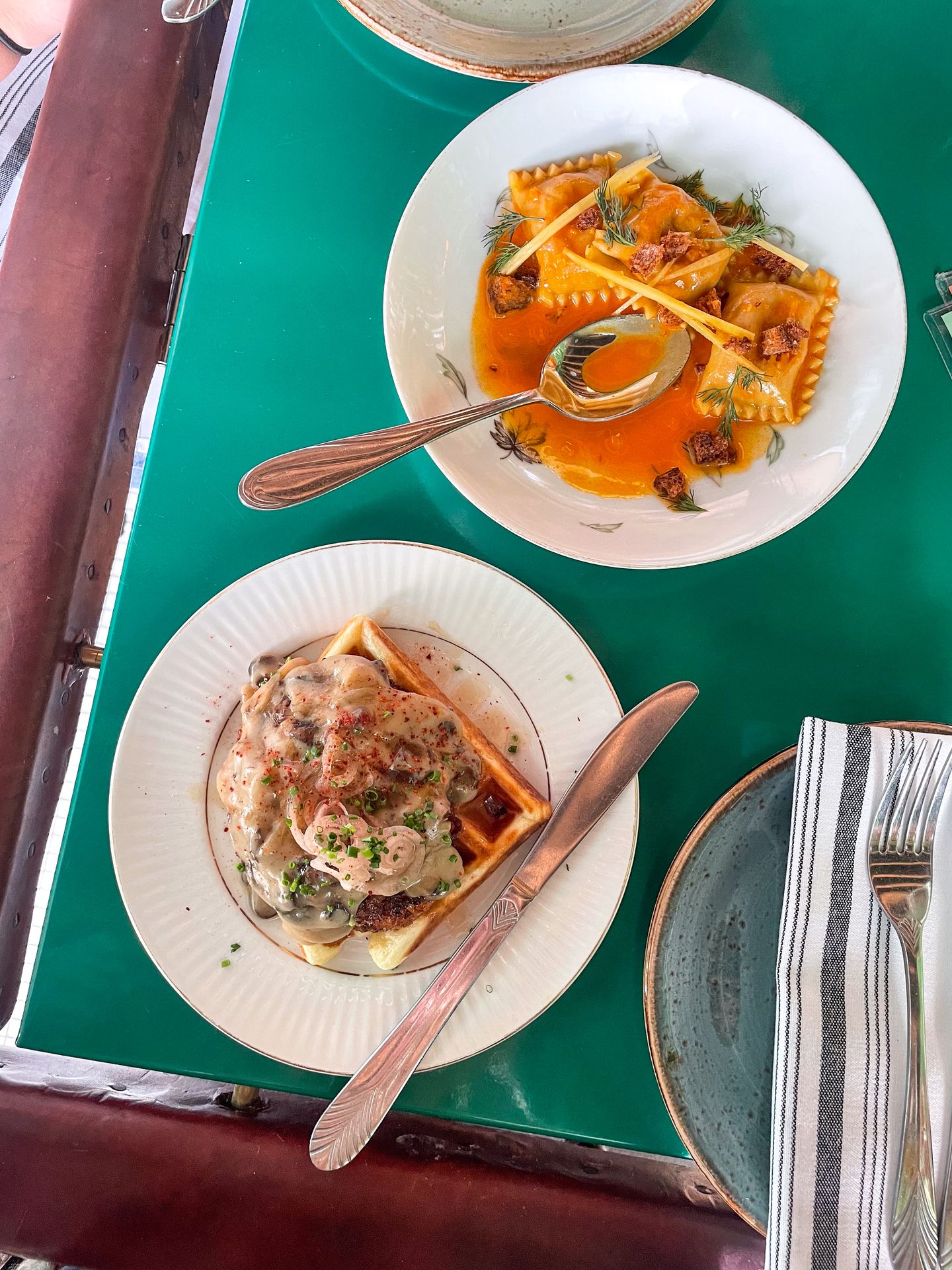 Two small plates at Mint Mark. One is a ravioli and the other is a vegetarian "chicken" and waffle.