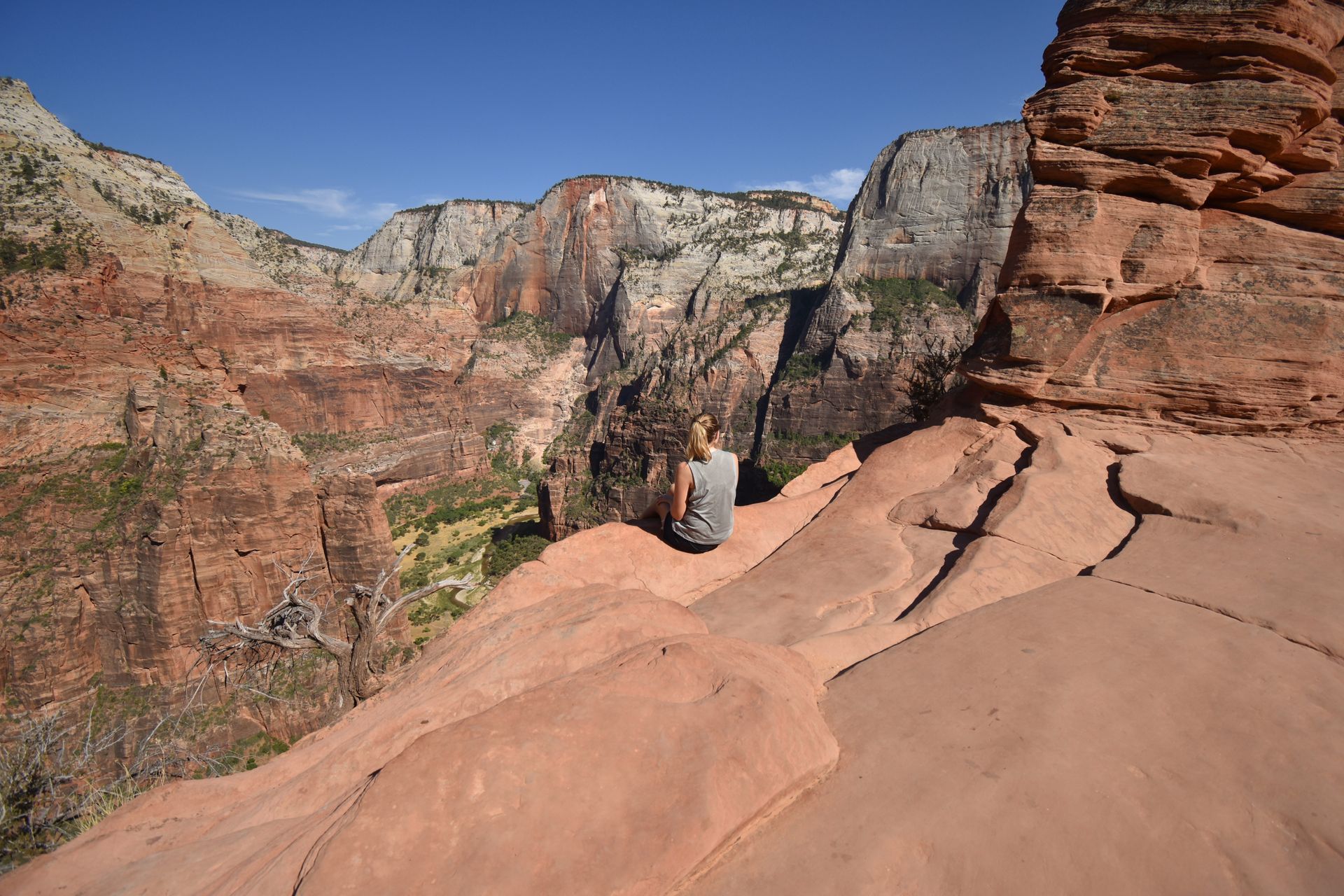 Lydia sitting on the edge of the cliff right outside of the chain portion of Angel's Landing