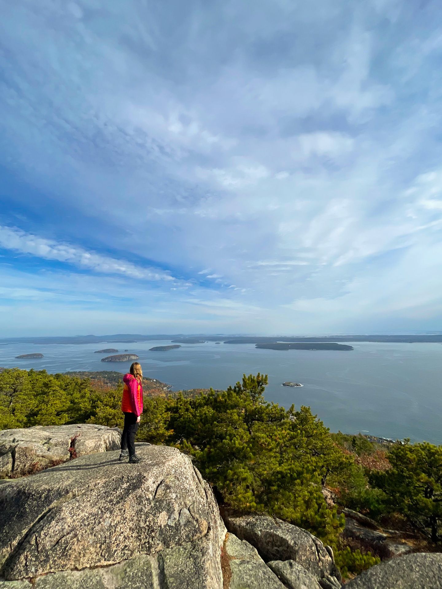 Lydia standing on a rock and looking out at the water from the top of the Precipice Trail.