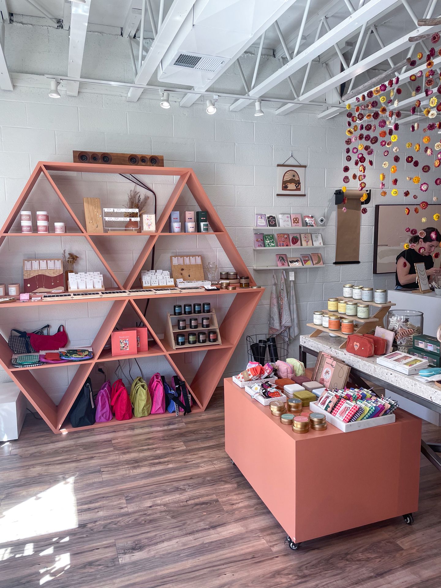 The interior of Mineral and Water. There is a pink shelf with bags, candles, jewerly and more.