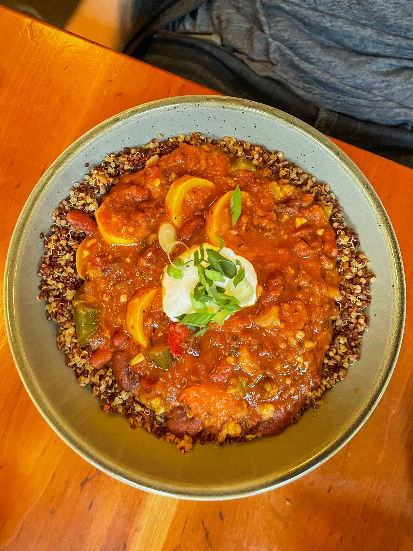 A plate of grains topped with veggies and a red sauce from Moosewood.