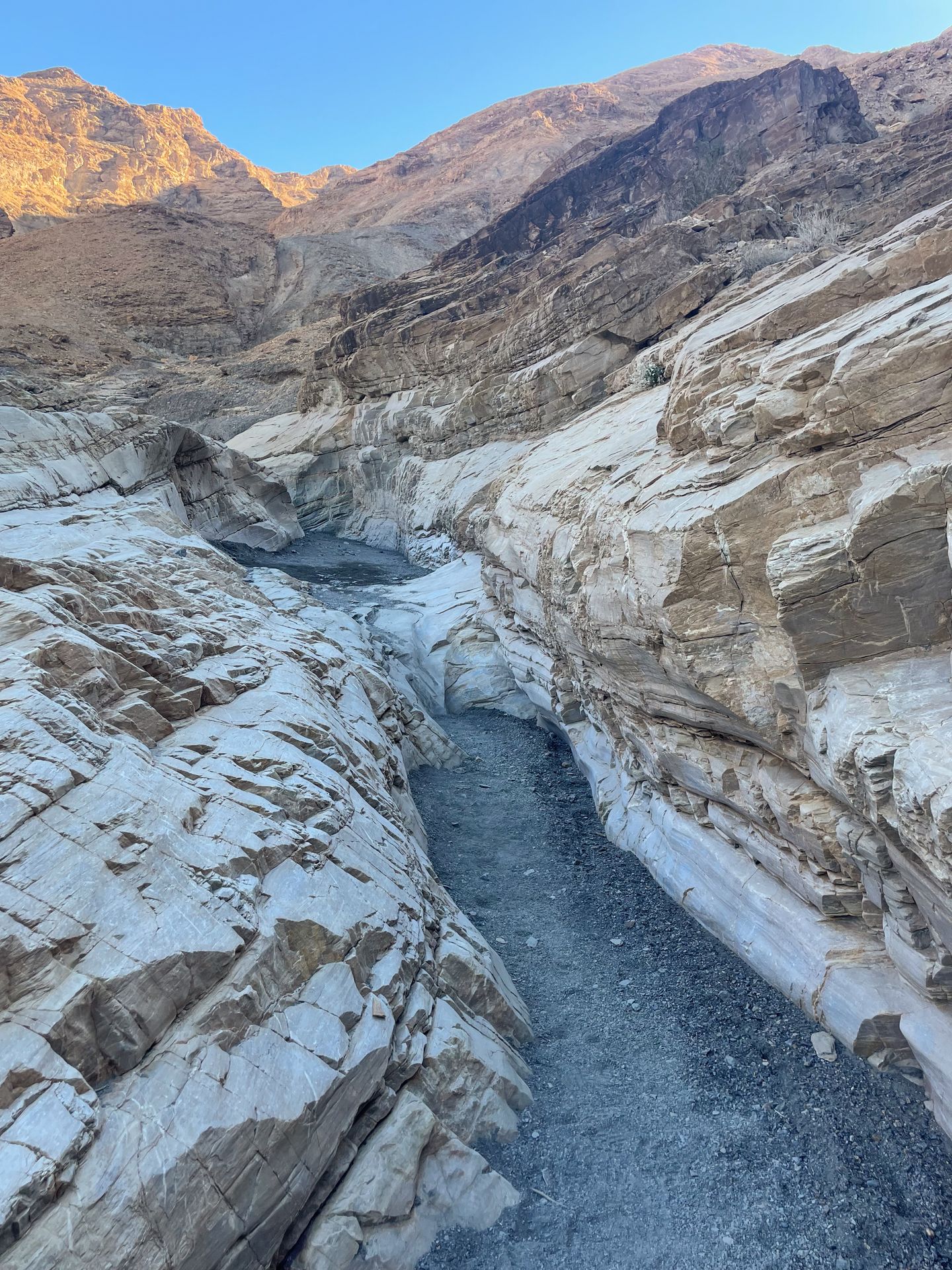 A narrow section of trail between white rocks on the Mosaic Canyon Trail.