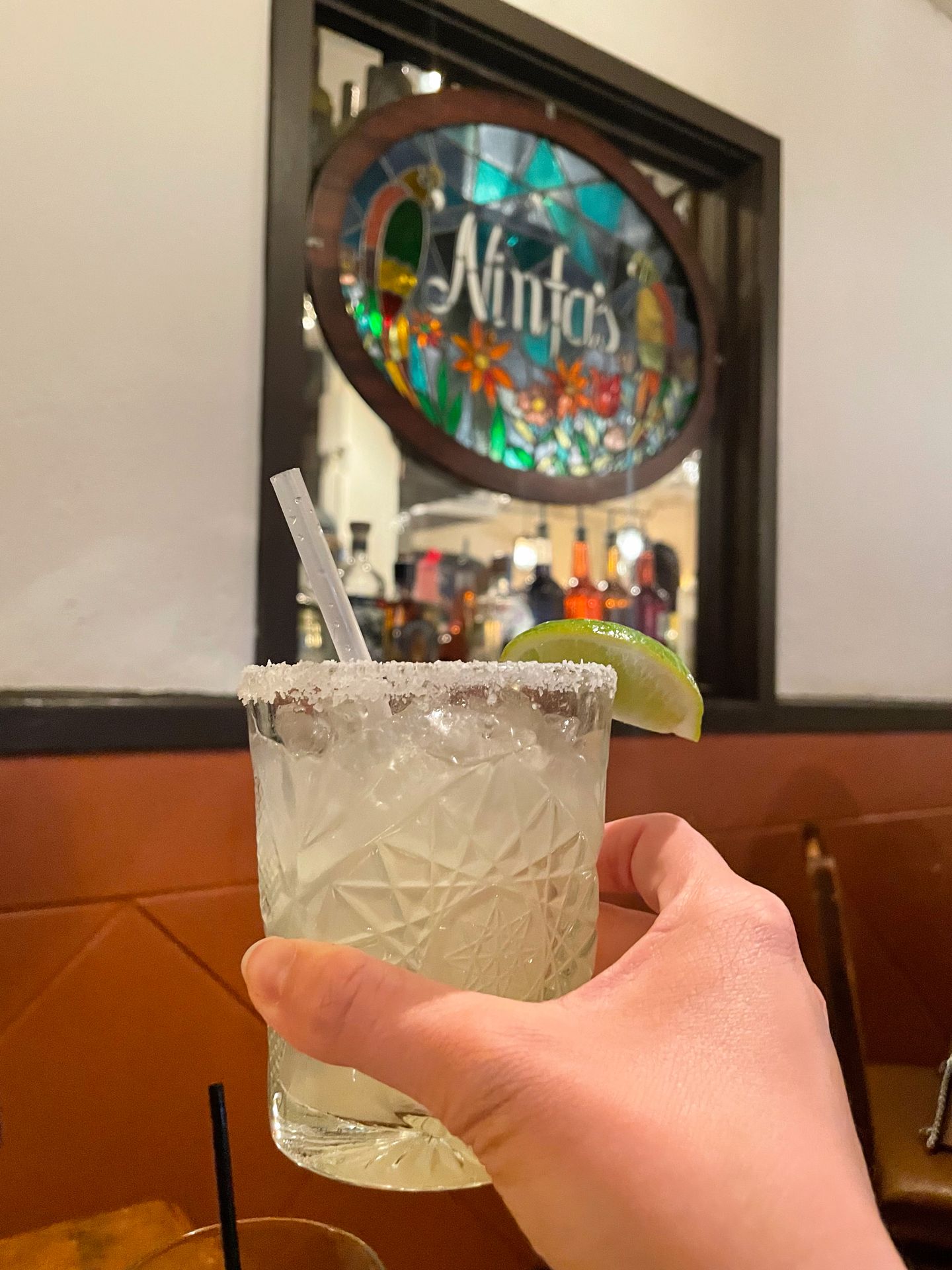 Holding up a margarita in front of a stained glass window inside of Ninfa's