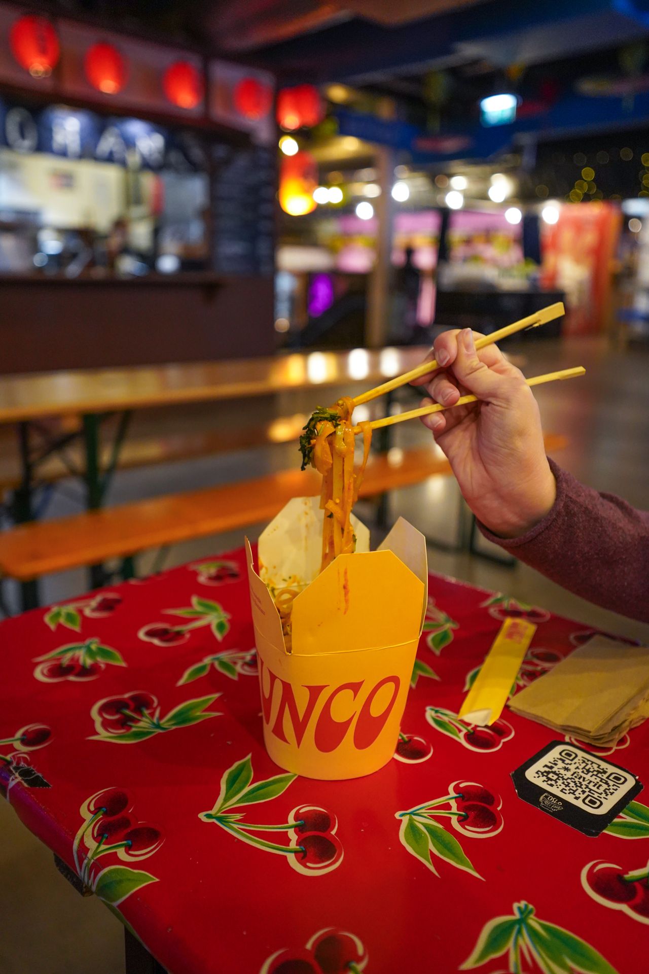 Pulling noodles up from a paper carton at Oslo Street Food