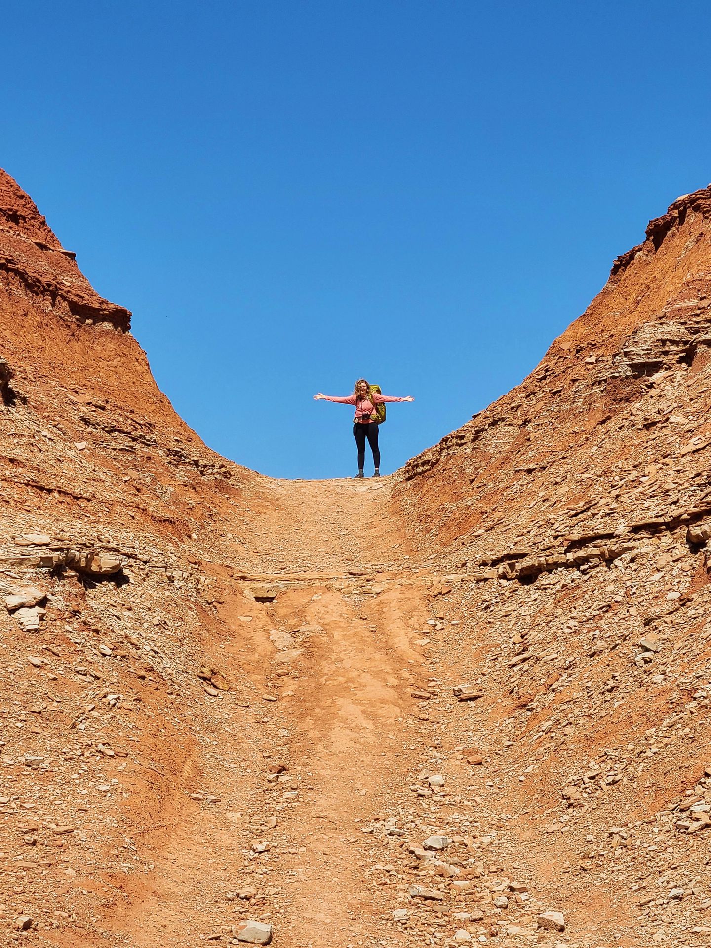 Lydia up a ledge wearing her large backpacking backpack.