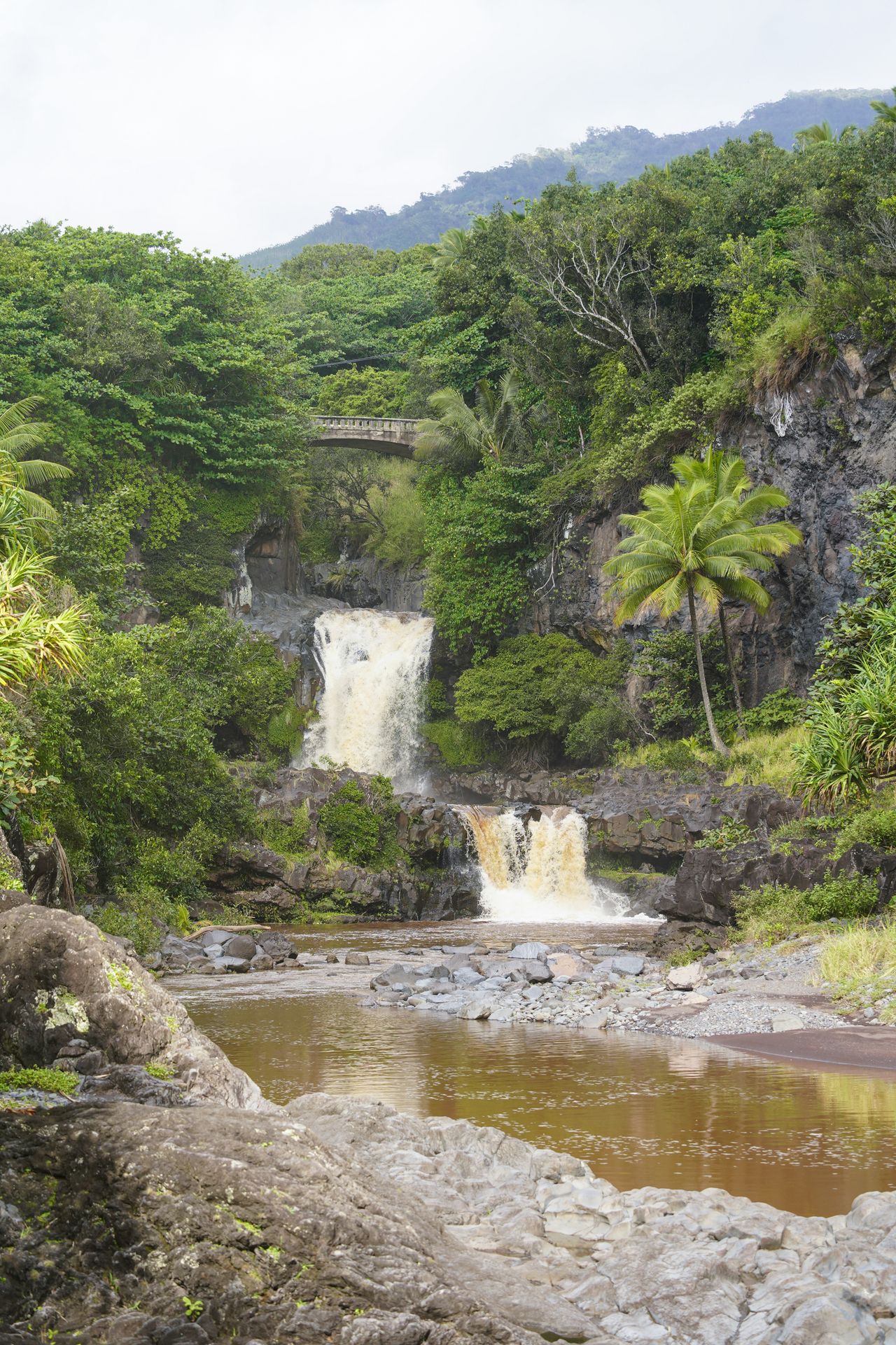 A two tiered waterfall, with a bridge above the falls
