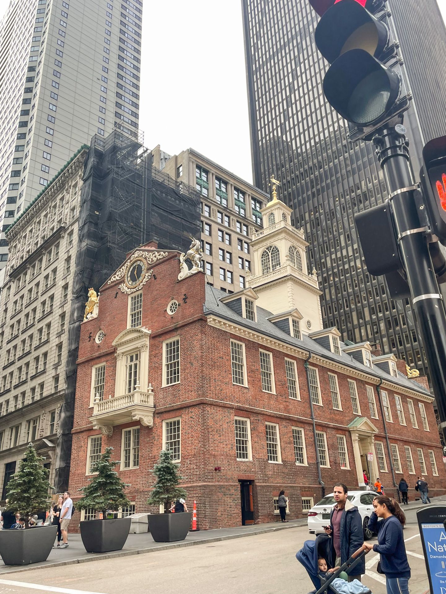 An historic brick building next to more modern buildings.