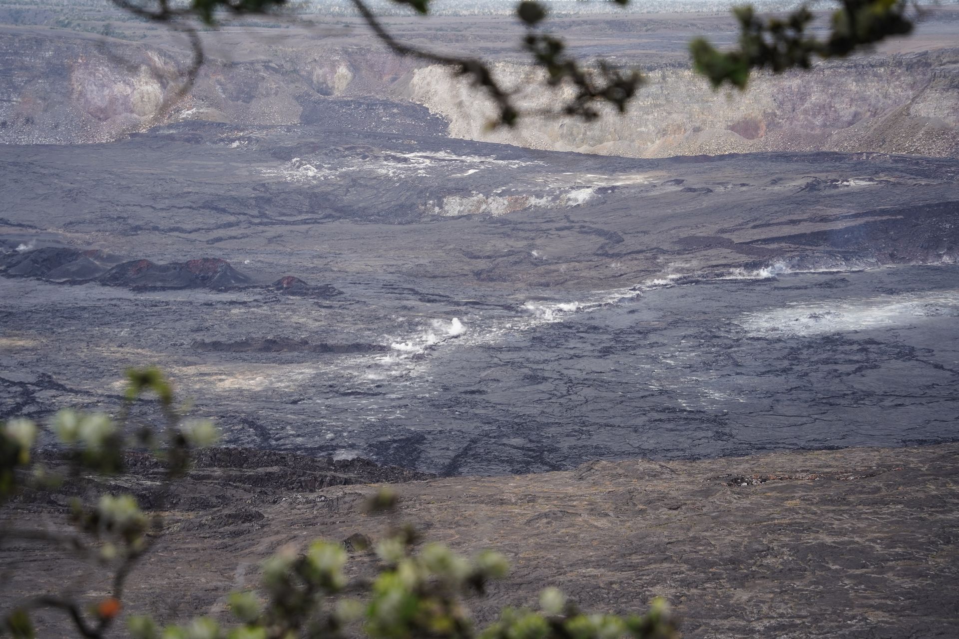 Looking down at the Kīlauea crater, which has some steam coming up between the cracks