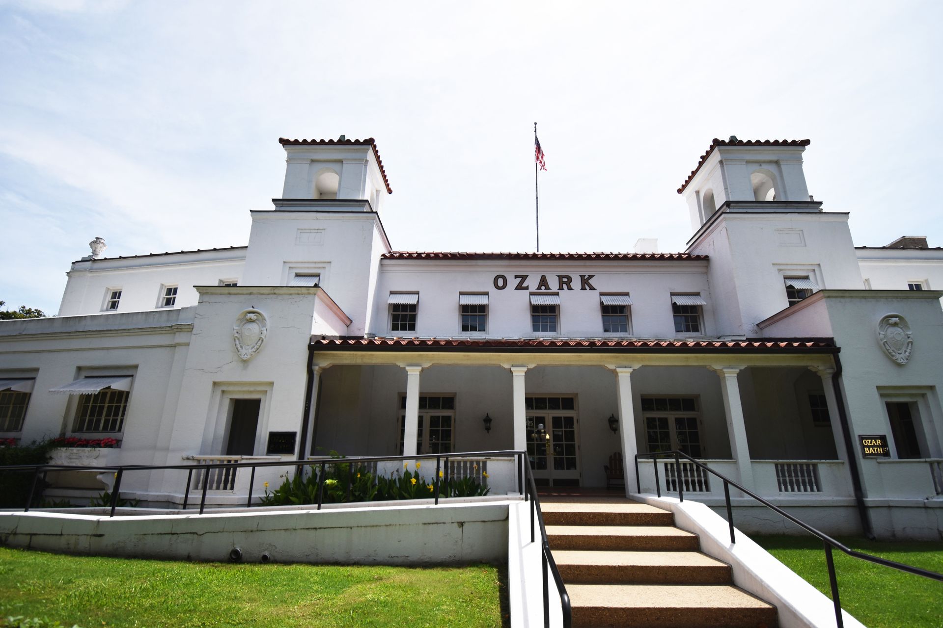 The exterior of Ozark Bathhouse, a white building with steps leading up to it.