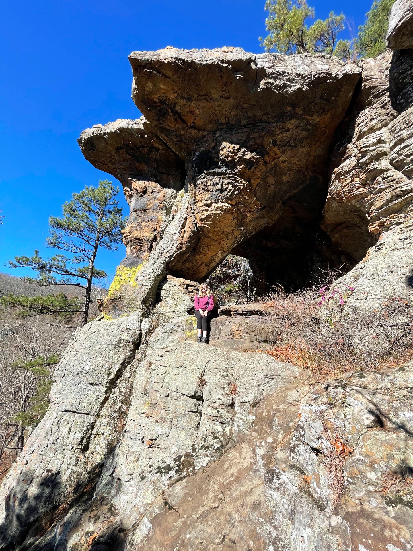 Lydia sitting on a rock with a pedestal rock behind her.