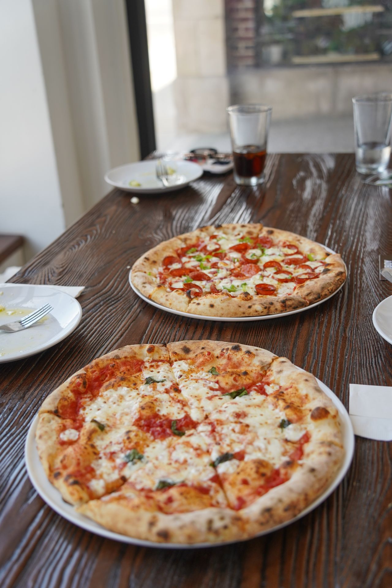 Two pizzas on a table in NoFo Pizza and Cafe