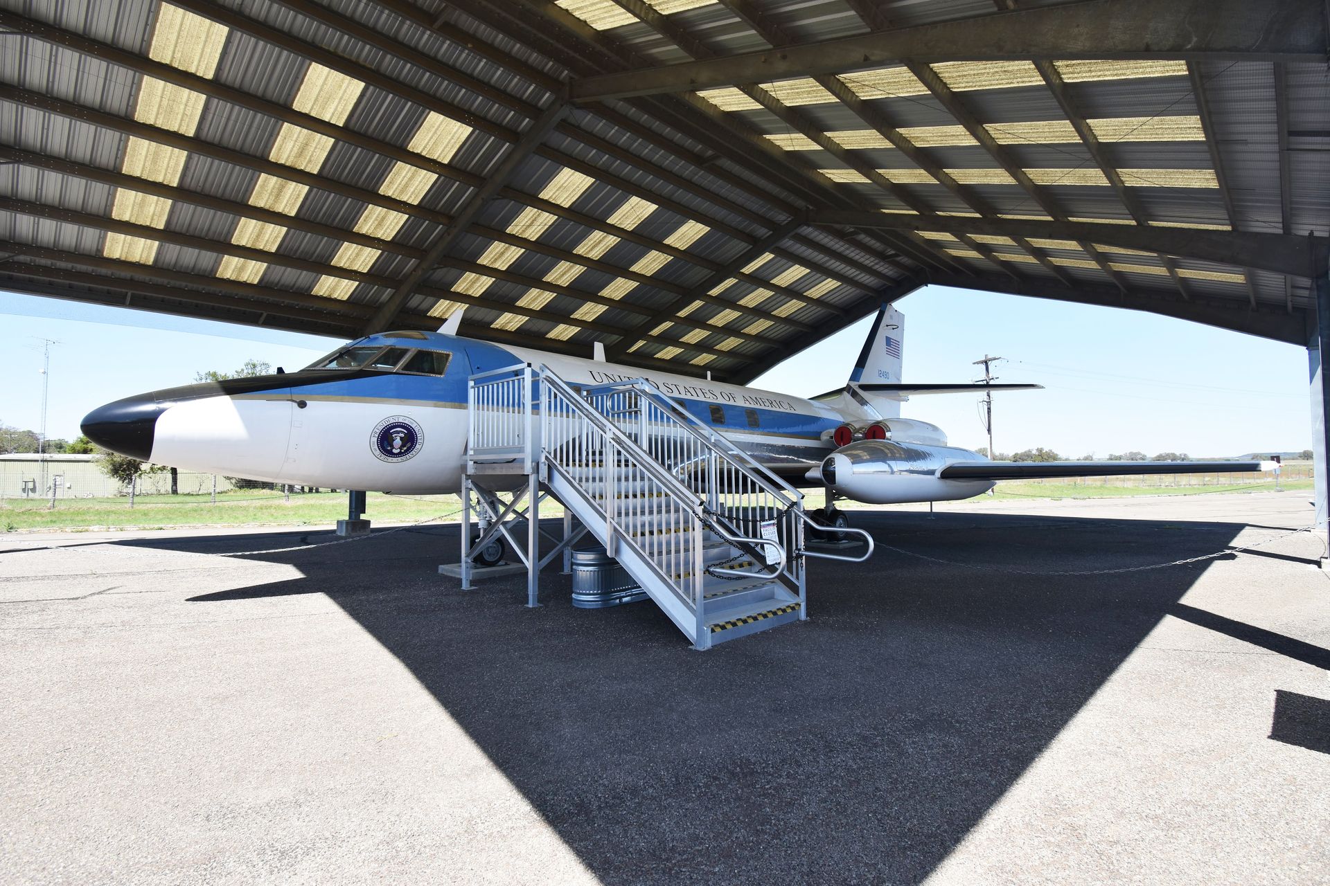 A plane sitting under a overhang at the LBJ Ranch.