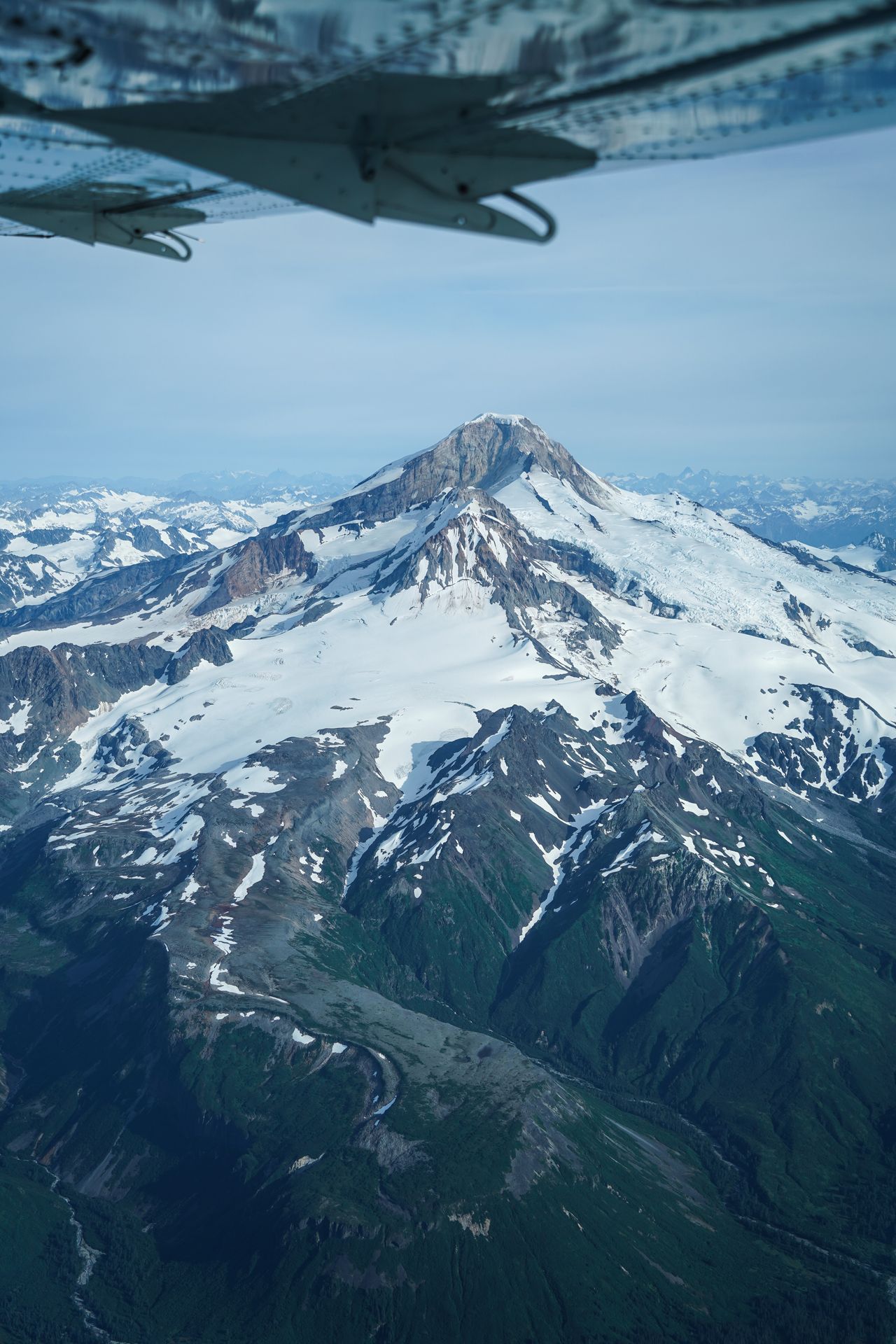 A tall mountain seen under the wing of a plane on the way to Katmai National Park