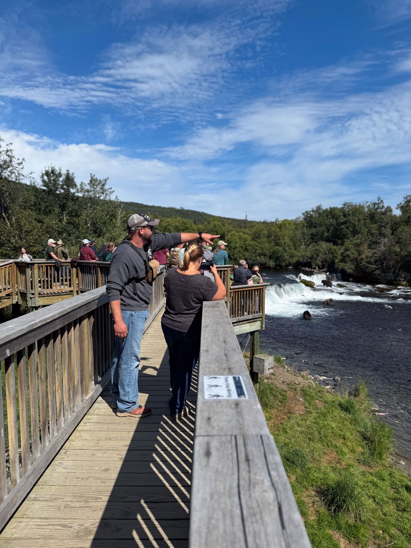 A crowd of people on the Upper Platform looking at Brooks Falls