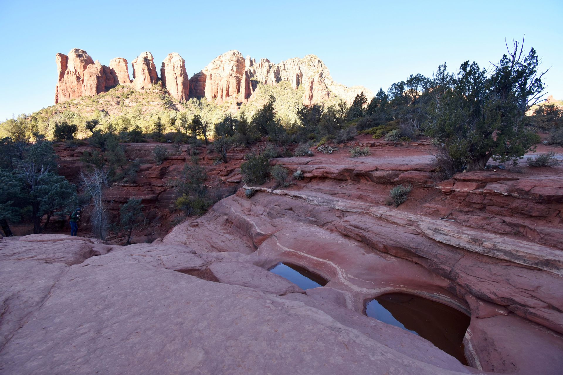 Two pools of water with jagged orange cliffs in the background.