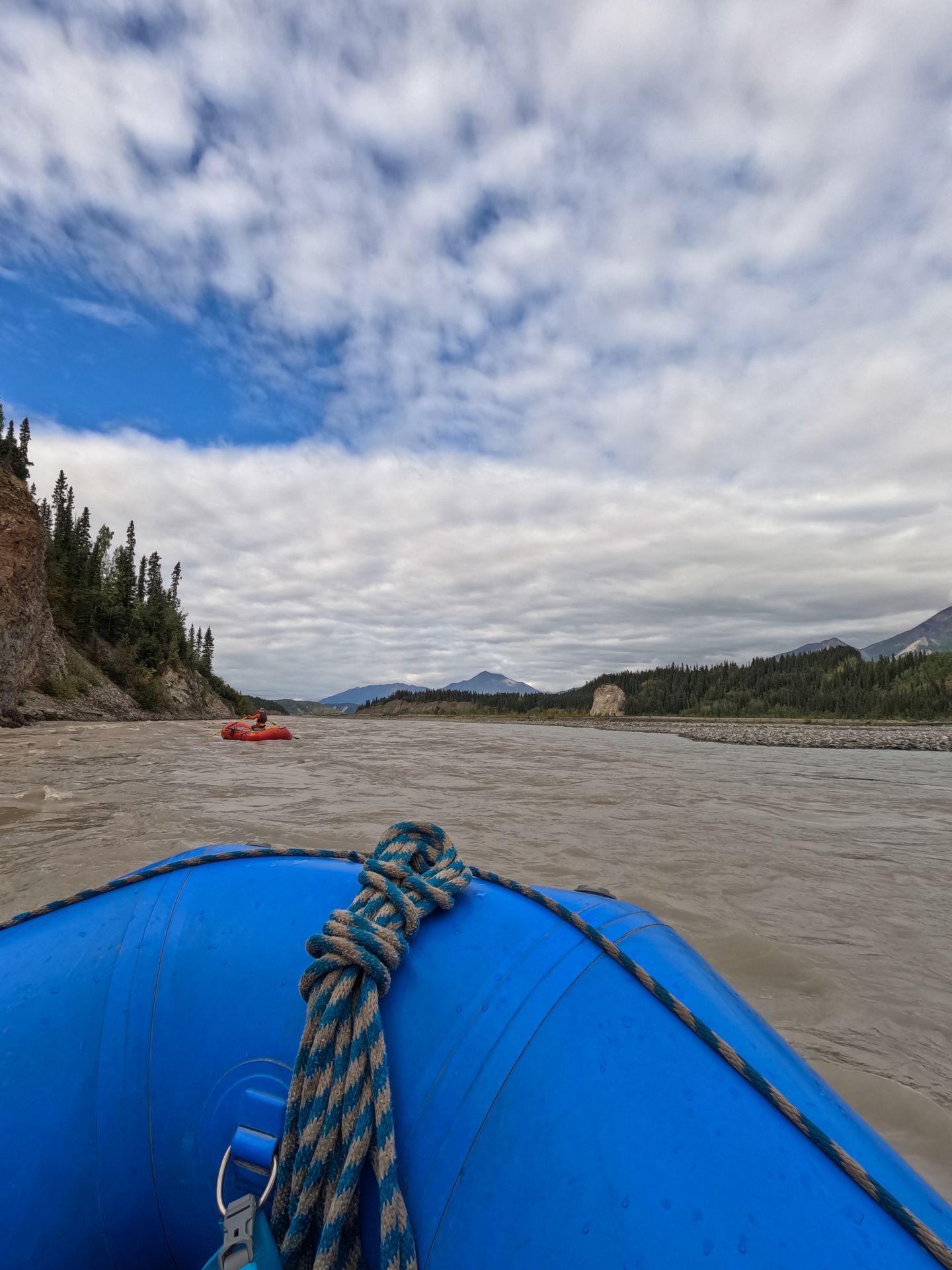 Looking out from a blue raft on a wide river