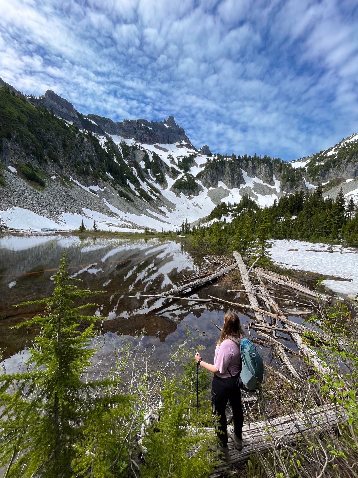 Lydia looking out at Snow Lake in Mount Rainier National Park. The mountains across the lake are covered in snow.